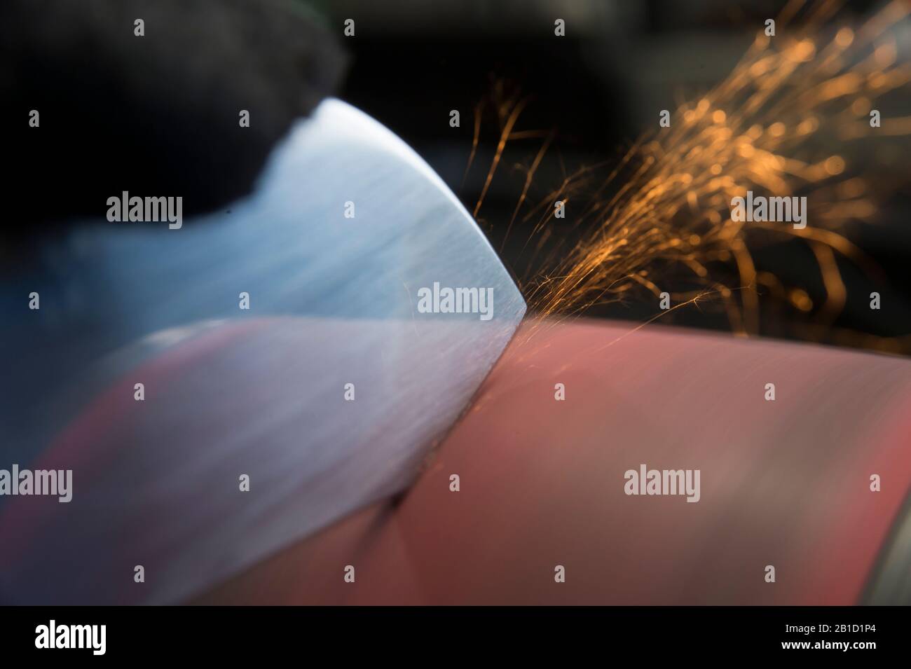 Polishing knife blade on sander Stock Photo Alamy