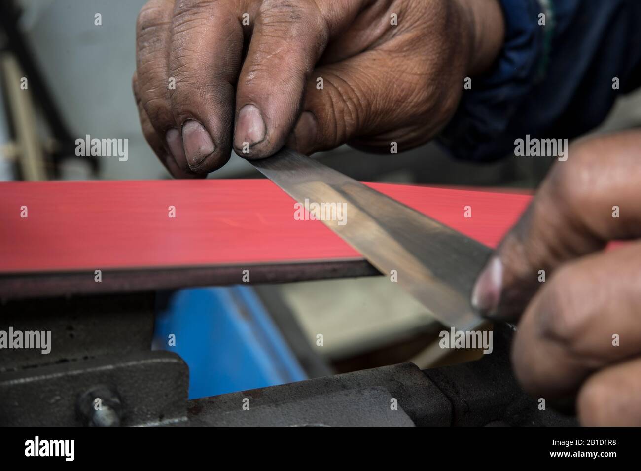 Polishing knife blade on sander Stock Photo Alamy