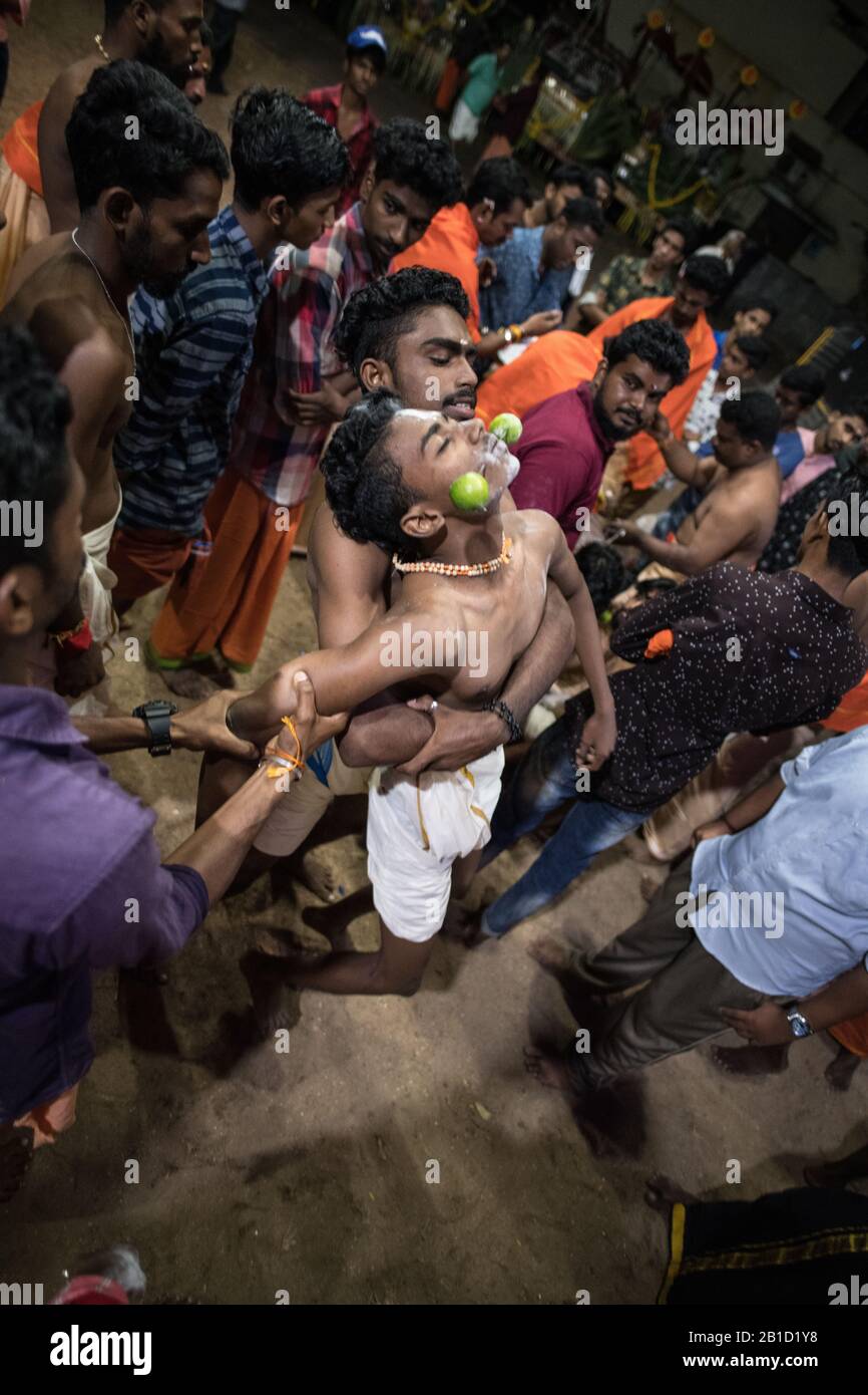 Devotees having a spear piercing in his mouth (Kavadi Aattam) as an act of devotion during Thaipooyam, or Thaipoosam, Festival in Kedakulam, Kerala. Stock Photo