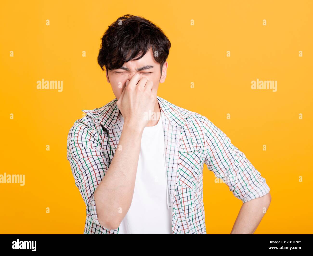 young man pinches nose with fingers .  disgust something stinks bad smell Stock Photo