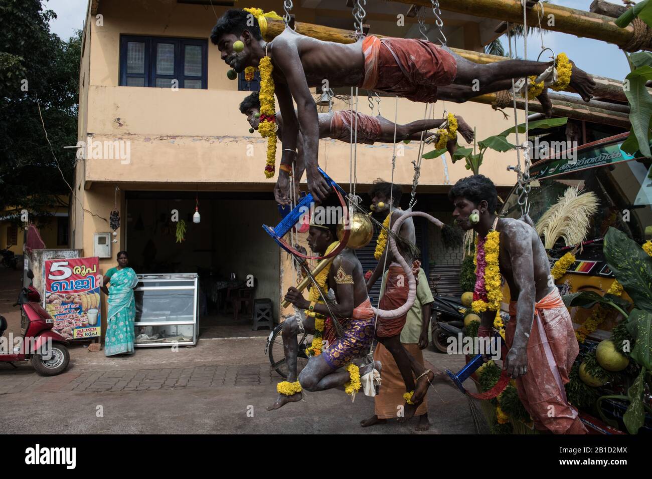 Devotees hanging by hooks piercing their skin as a ritualistic act of