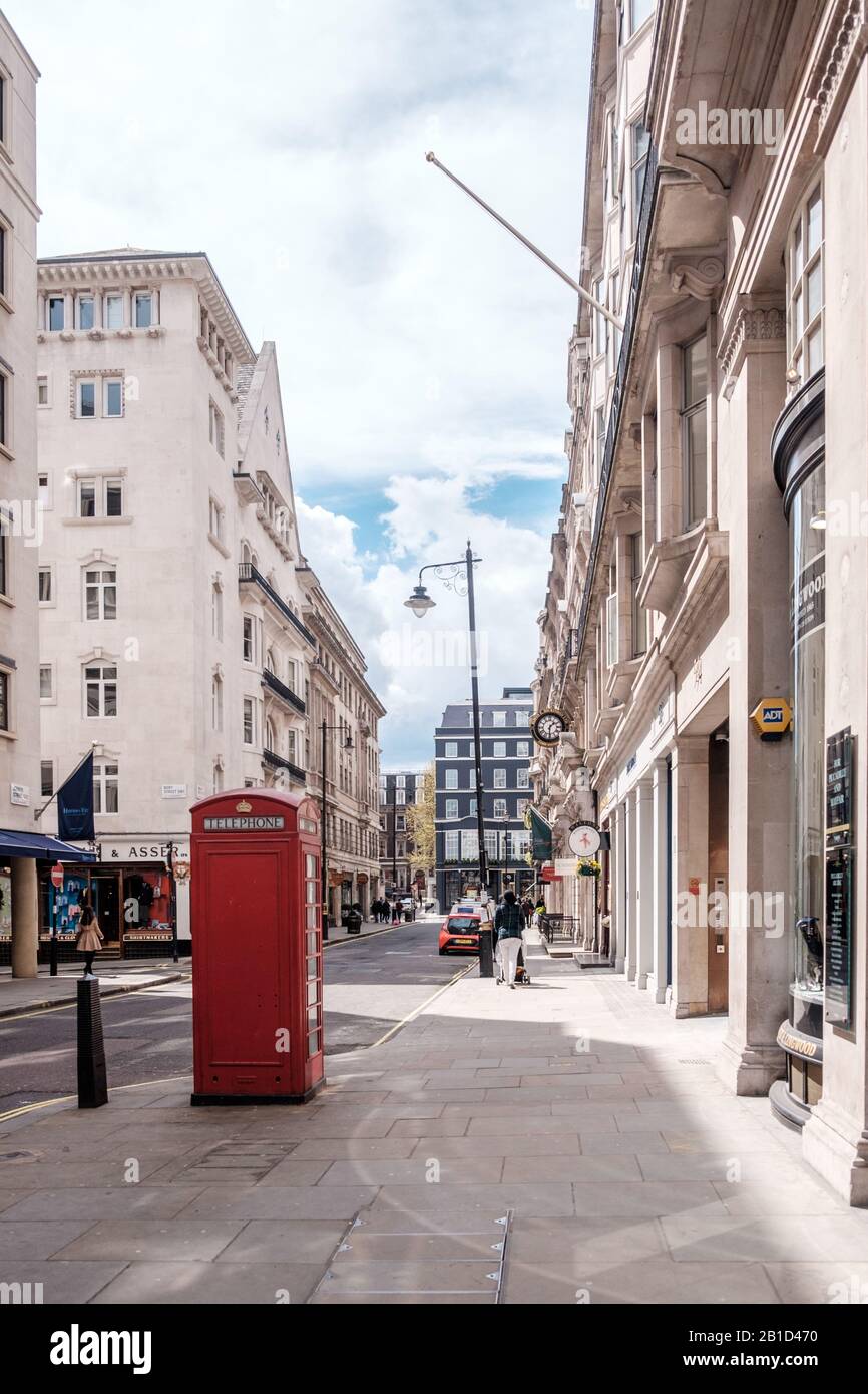 Iconic vintage red telephone booth located on side of the road, London, England Stock Photo
