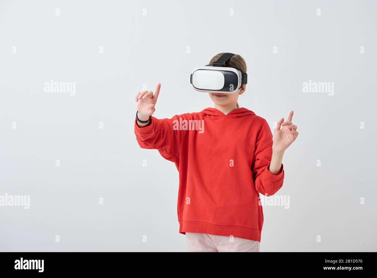 Content school girl in red hoodie gesturing hand while enjoying virtual ...