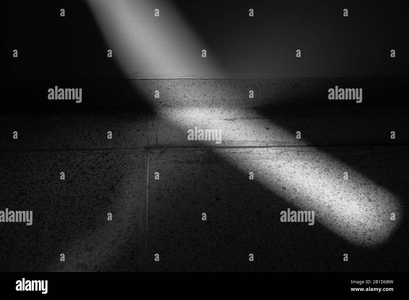Close up view of ray of light falling on wall and then changing angle along floor Stock Photo