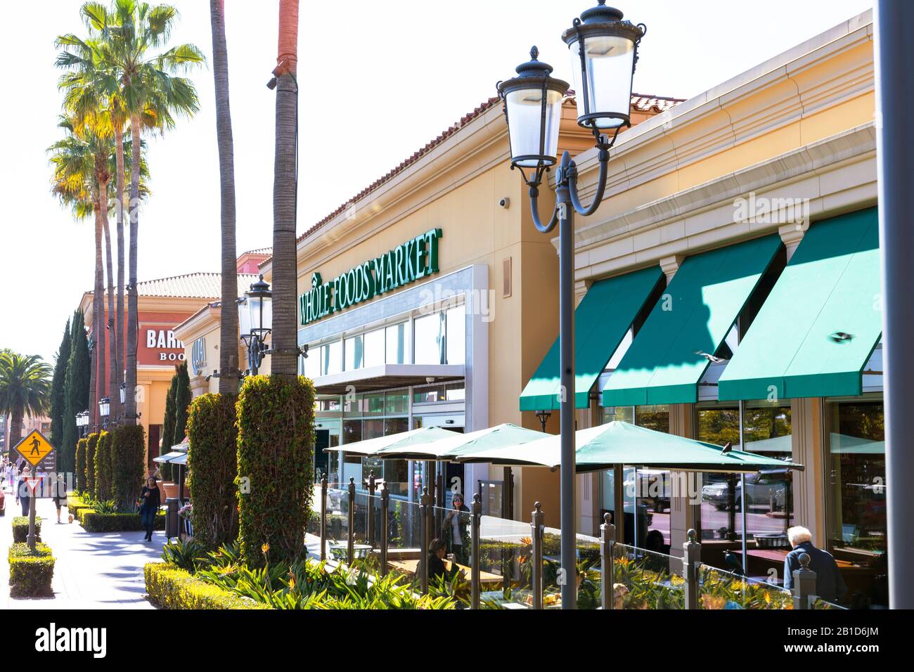 The Wholefoods Market in Fashion Island has palm trees, green awnings, and decorative lamps at the storefront.  Newport Beach, California. Stock Photo