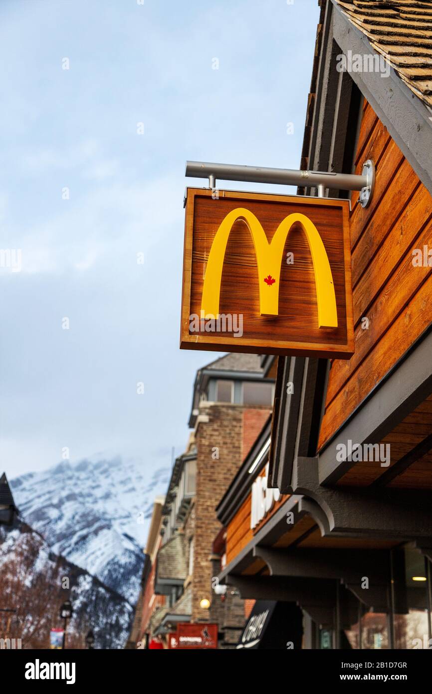 BANFF, CANADA - FEB 15, 2020 : McDonald's Restaurant with its unique Canadian maple leaf sign on busy Banff Avenue in Alberta, Canada. The famous Amer Stock Photo