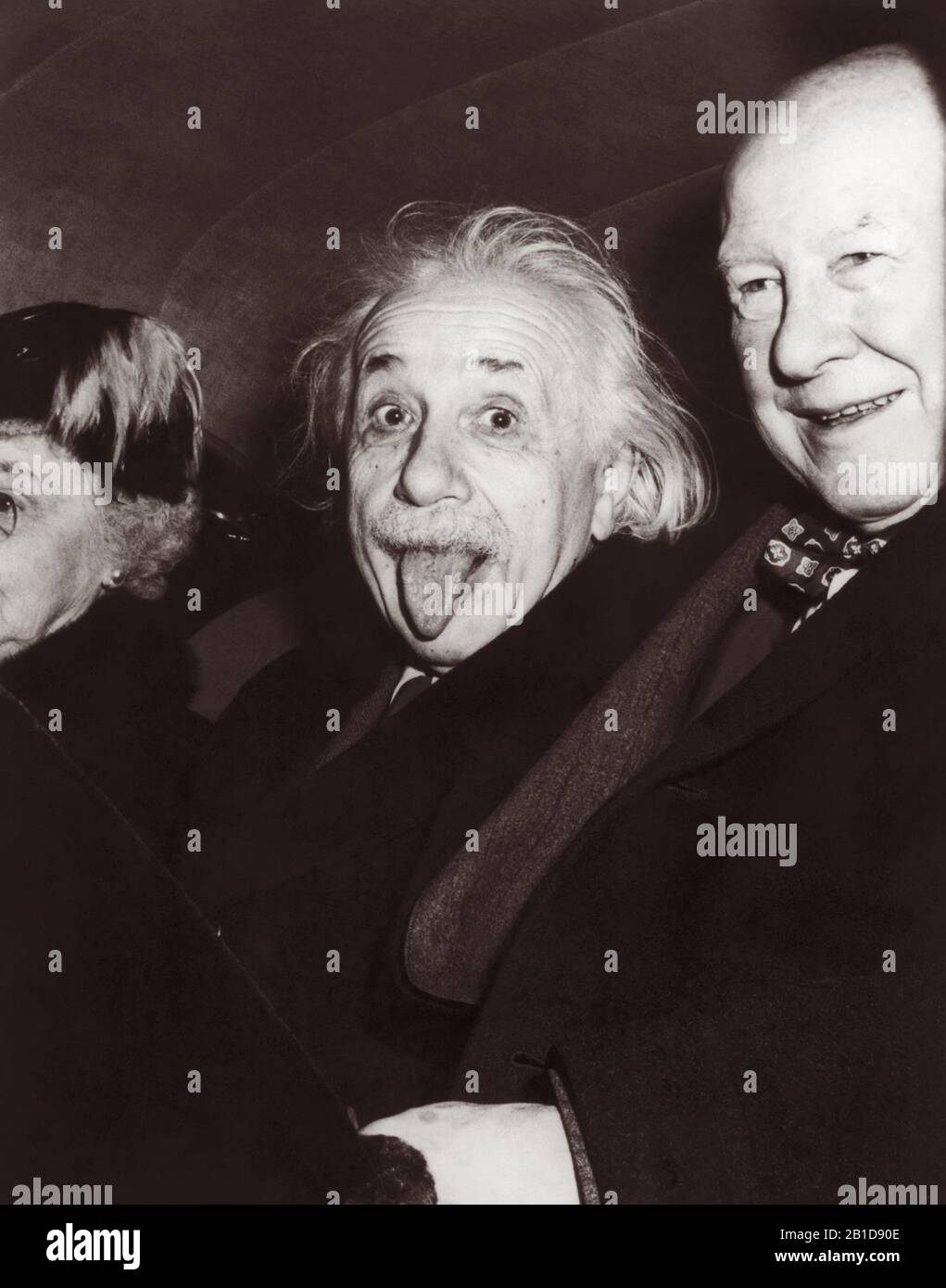 Iconic photo of Albert Einstein sticking out his tongue on the occasion of his 72nd birthday party at Princeton University on March 14, 1951. Photographer Arthur Sasse captured the split-second image as Einstein was leaving the event, seated in the back seat of a car between Dr. Frank Aydelotte, former head of the Institute for Advanced Study at Princeton University, and Aydelotte's wife, Marie Jeanette. Stock Photo