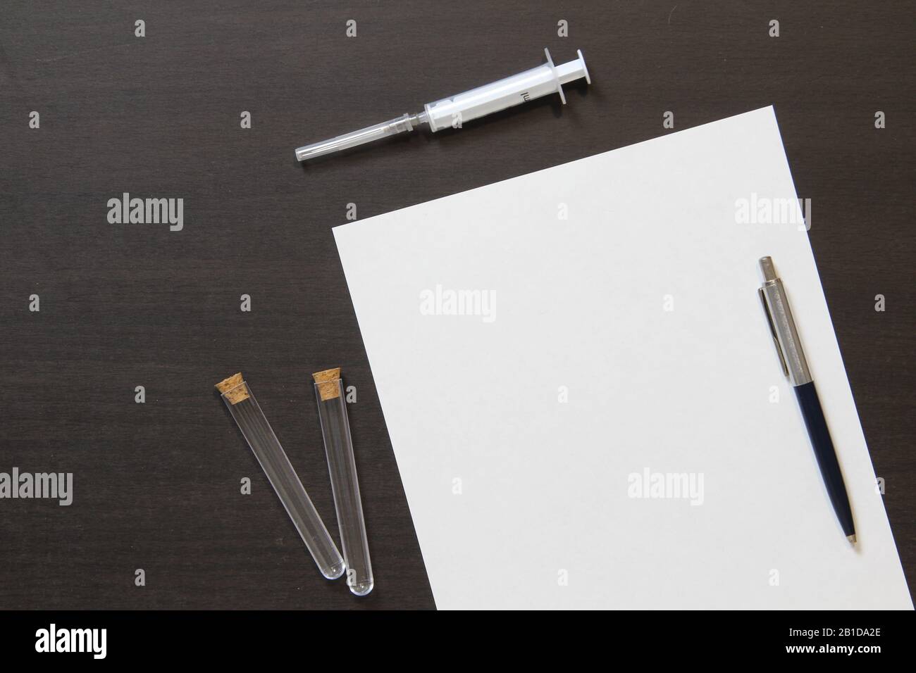 Template of white paper with pen and syringe for injection on dark ...