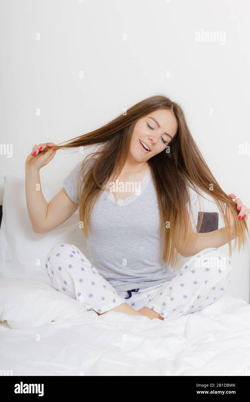 Morning sleep rest fun relax concept. Girl pulling hair in bed. Young