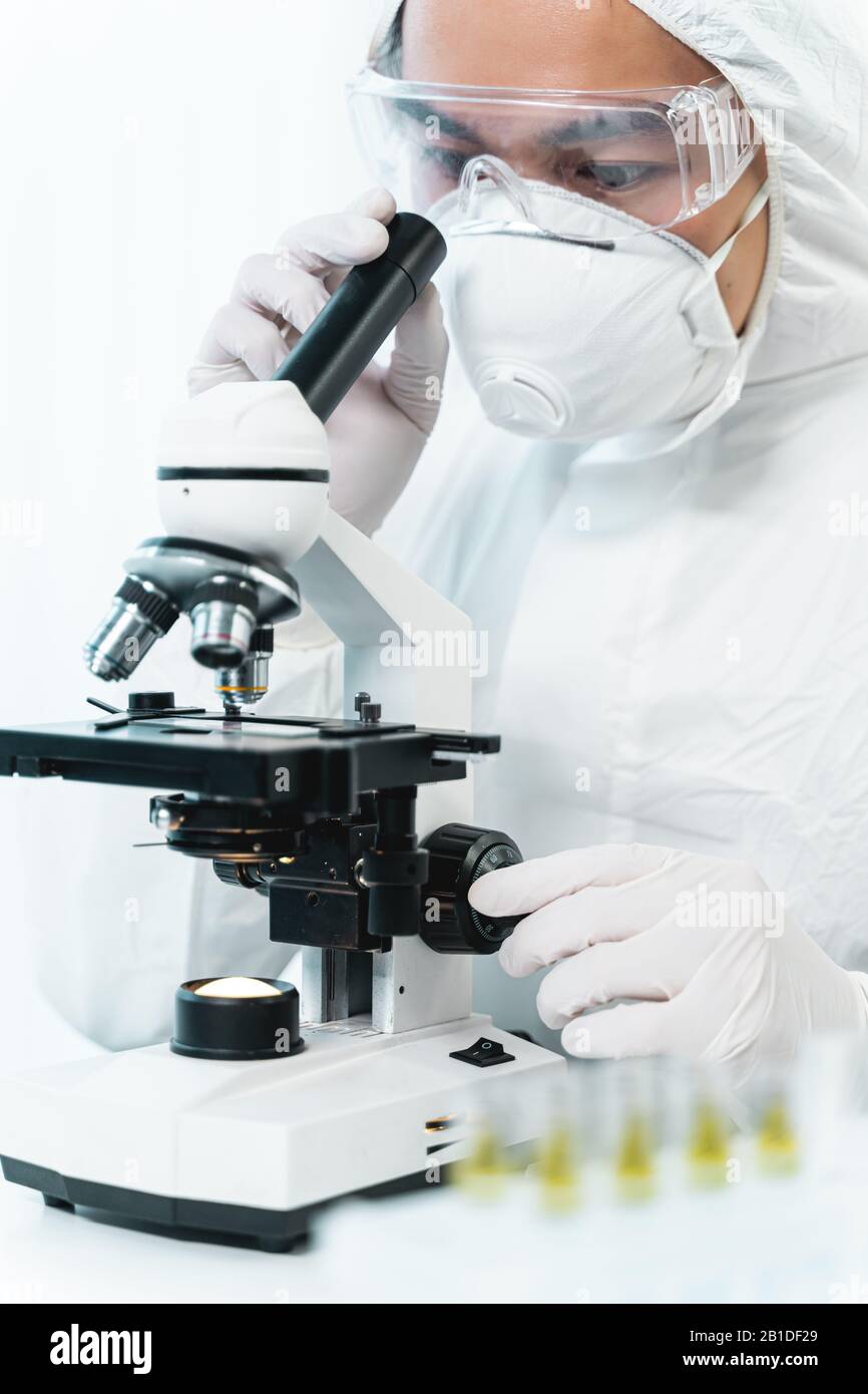 Concentrated young medical worker using modern microscope Stock Photo