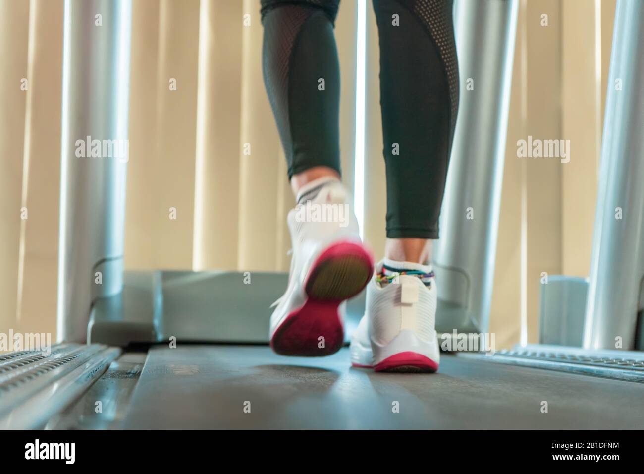 Close up of woman shape legs while running on the treadmill in the