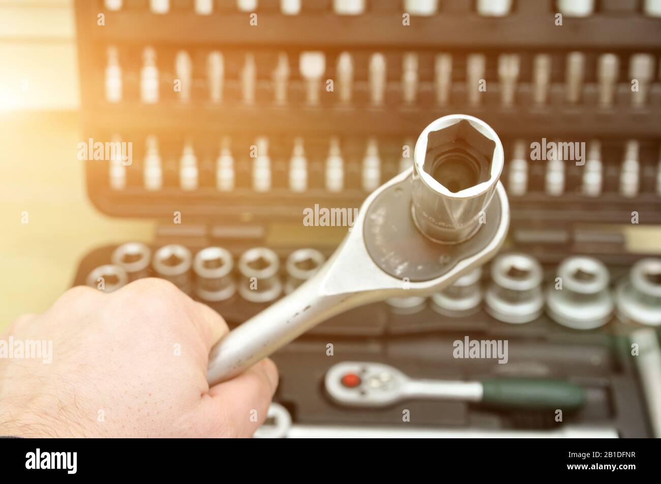 car repair. hand with a wrench on the background of a toolbox. Bits, screwdrivers, wrenches of different sizes Stock Photo