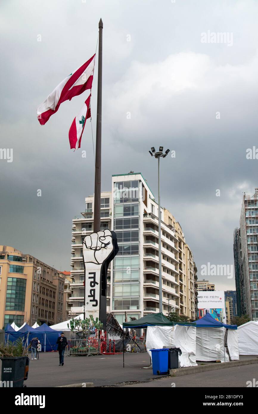 Lebanese flag and revolutionary hand monument raised at Martyr's Square in downtown Beirut where protests and demonstrations are taking place Stock Photo