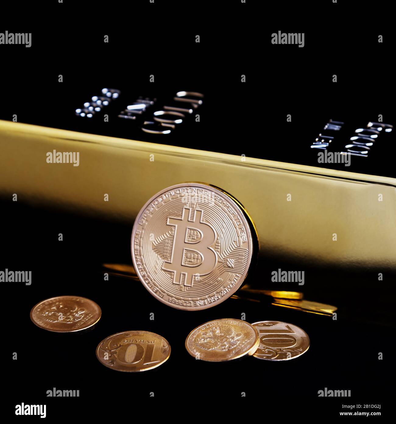 Bitcoin cryptocurrency and gold bar on a black background Stock Photo -  Alamy