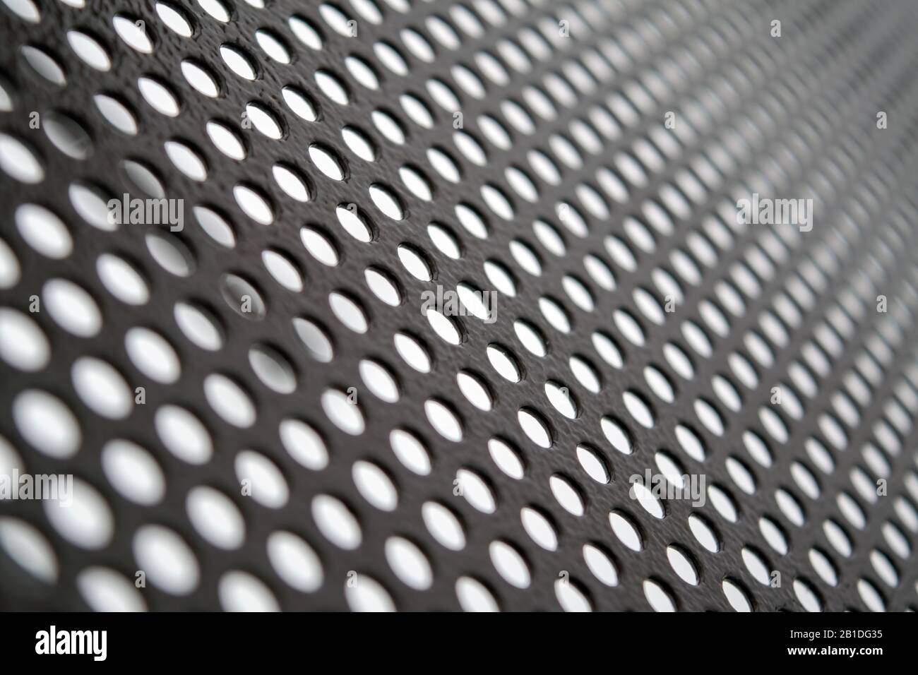 Perforated metallic grid, industrial background. Steel plate with holes. Stock Photo