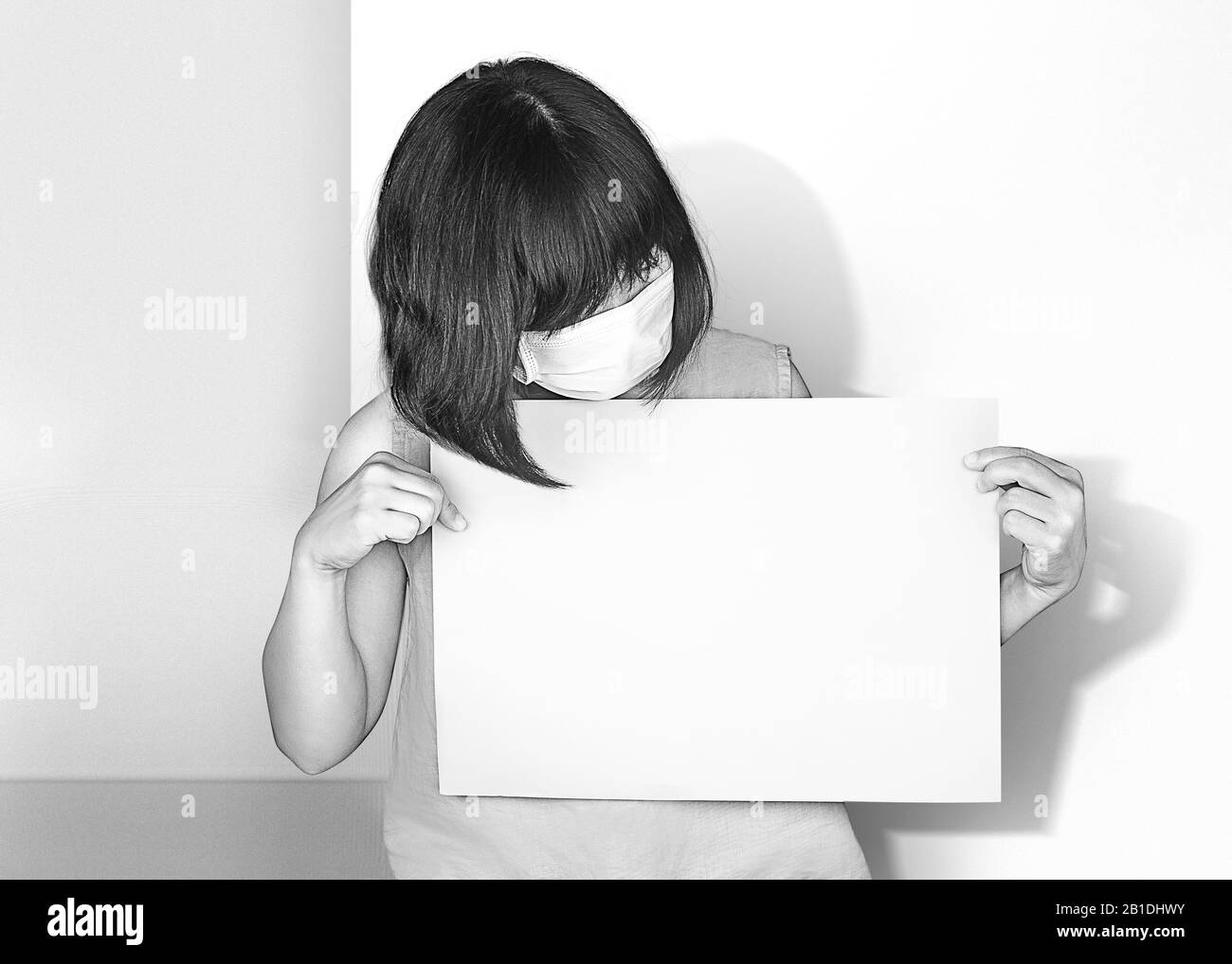 Asian woman holds white paper. Wear masks to prevent disease, prevent dust, Asians are not viruses concept, anti racism concept Stock Photo