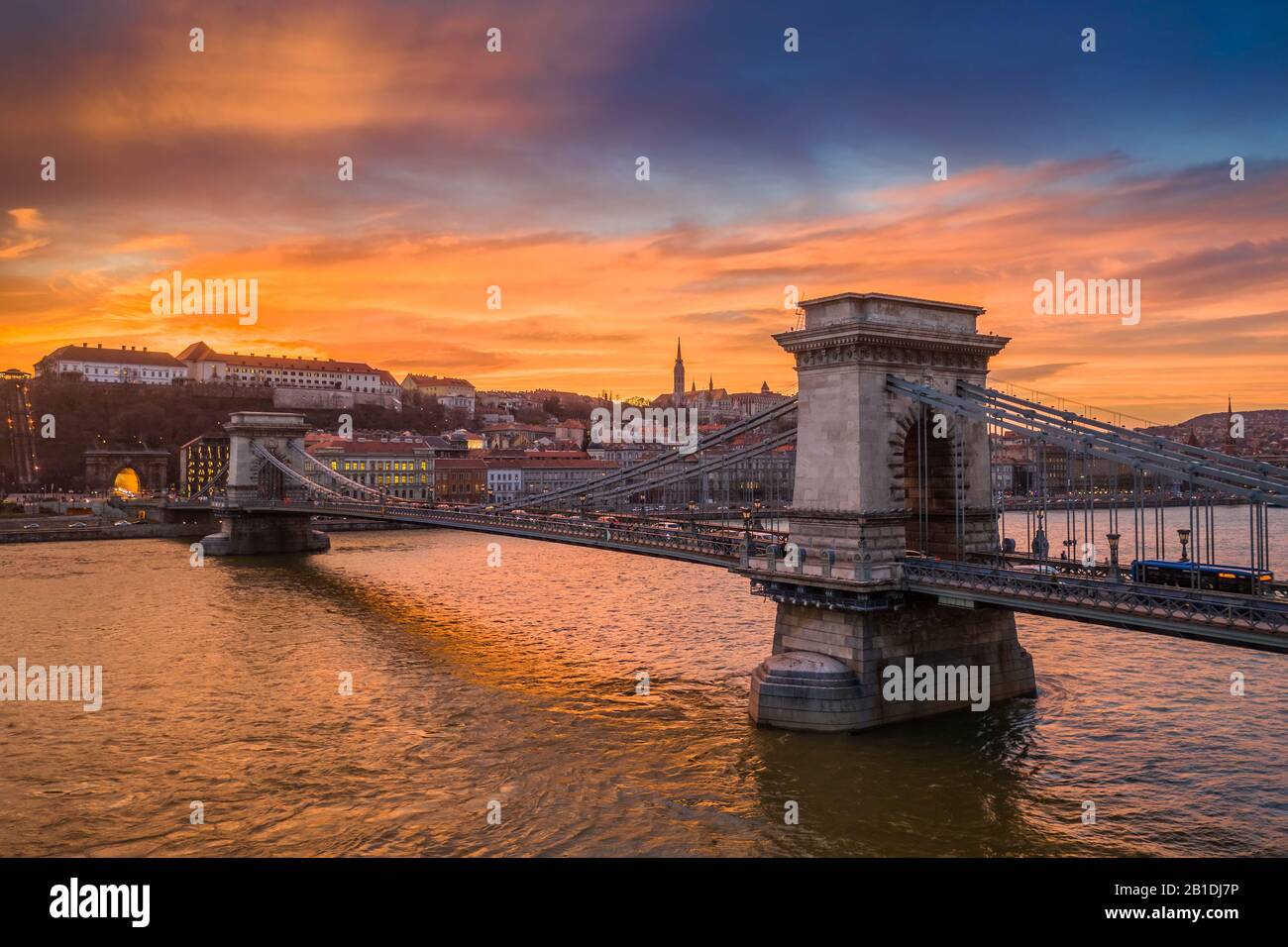 Budapest, Hungary - Aerial view of the famous Szechenyi Chain Bridge with a beautiful golden sunset at winter time. Matthias Church and Fisherman's Ba Stock Photo