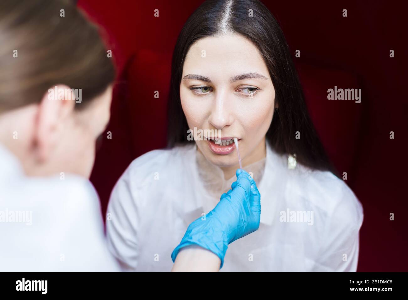 young girl in the beauty parlor. Doctor humidifies lips gel. dentistry hygiene Stock Photo
