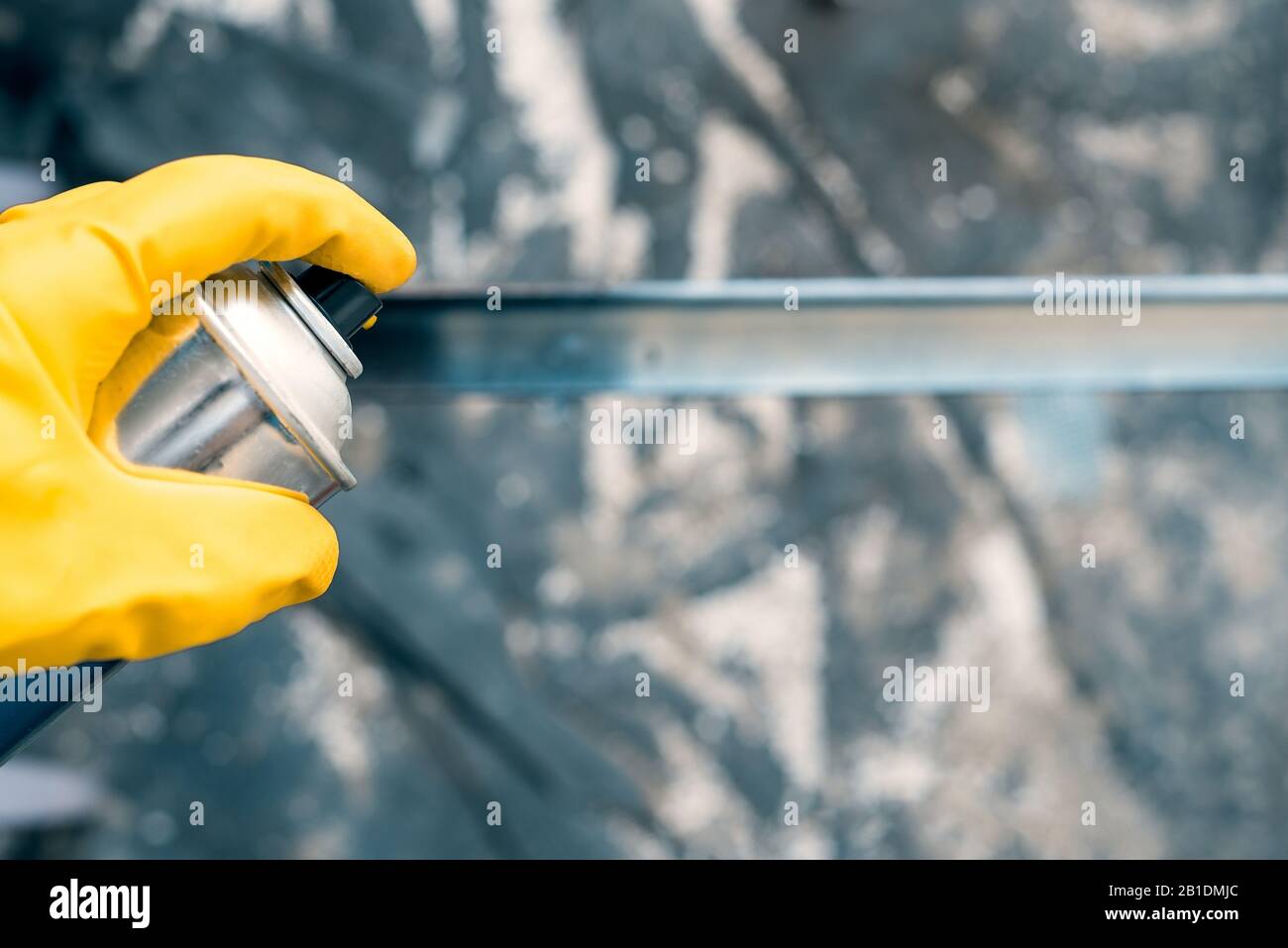 spray paint. hand in yellow rubber glove holding a spray bottle. repairs Stock Photo Alamy