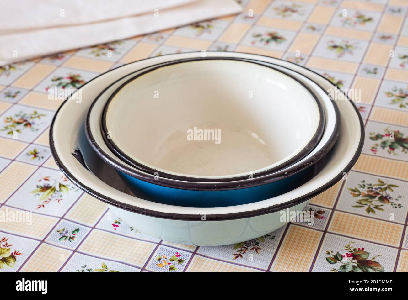 Pile of old enamel dishes, or bowls, on a kitchen table Stock Photo