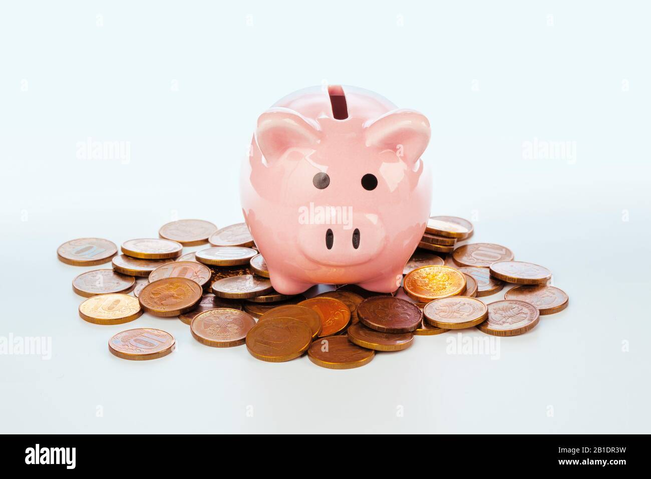 Pink piggy bank and coins isolated on white Stock Photo