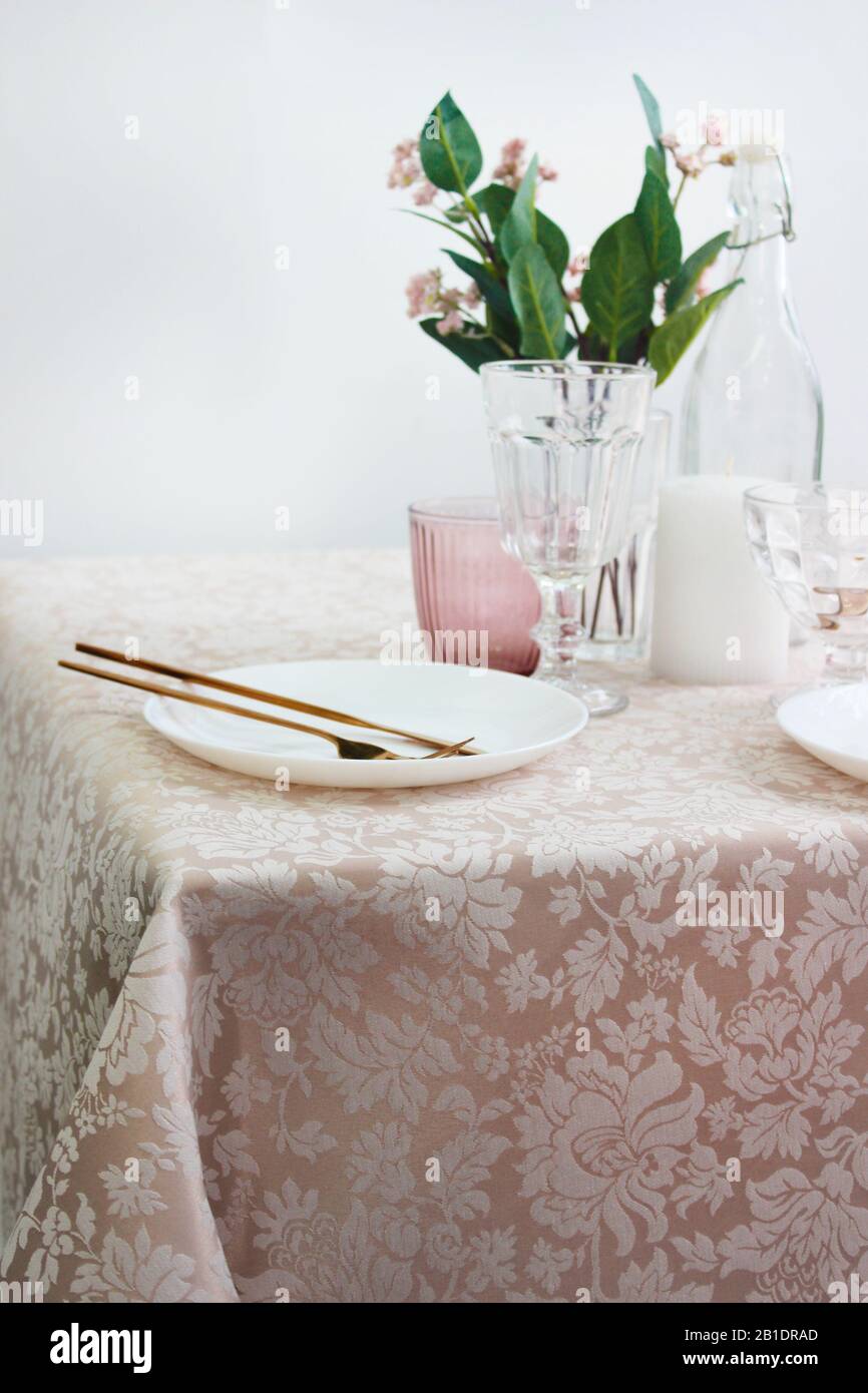 festive table setting with plates and cutlery, bright interior. Stock Photo
