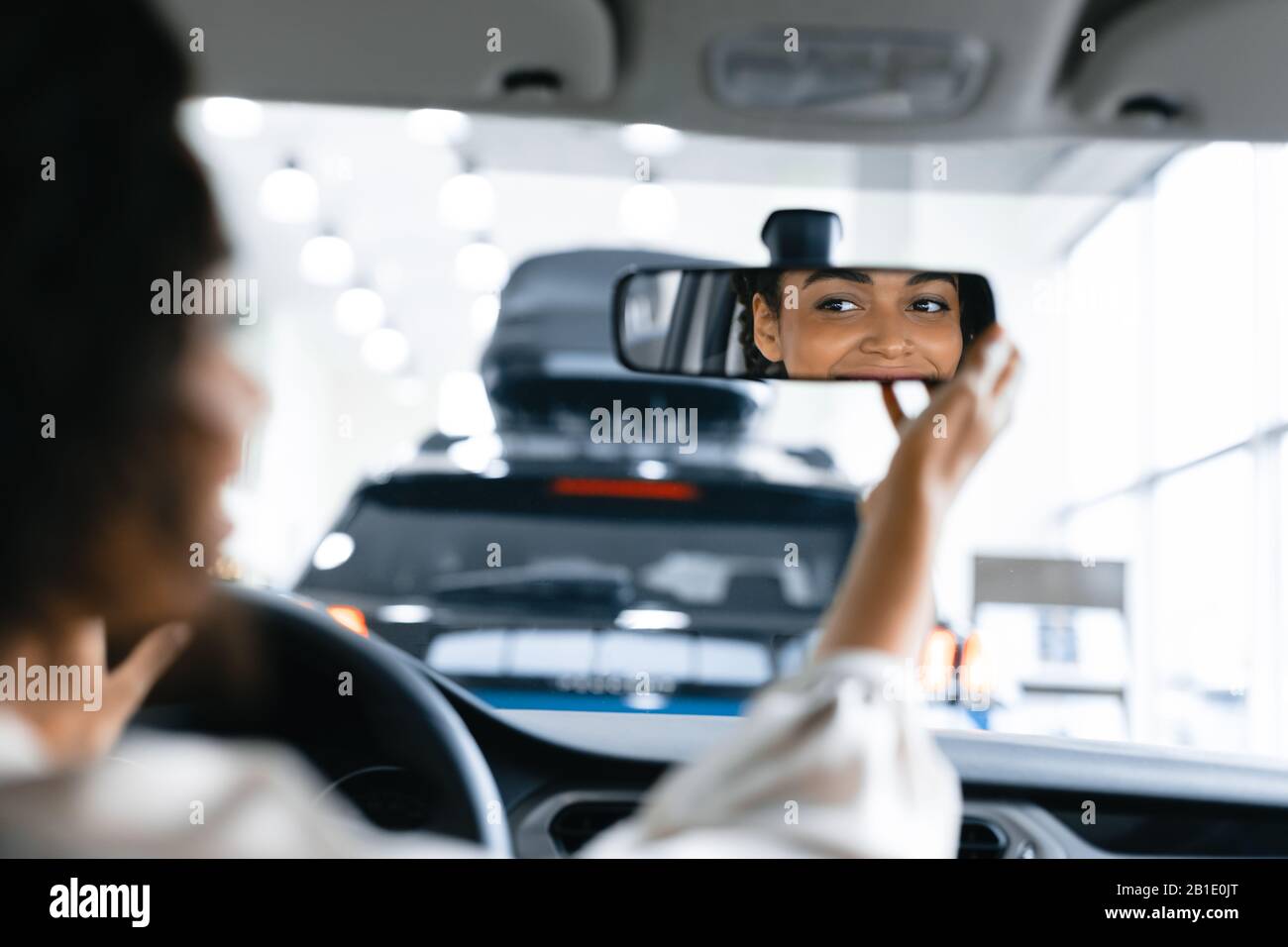 Girl Checking Mirrors Sitting In Driver's Seat In Dealership Store