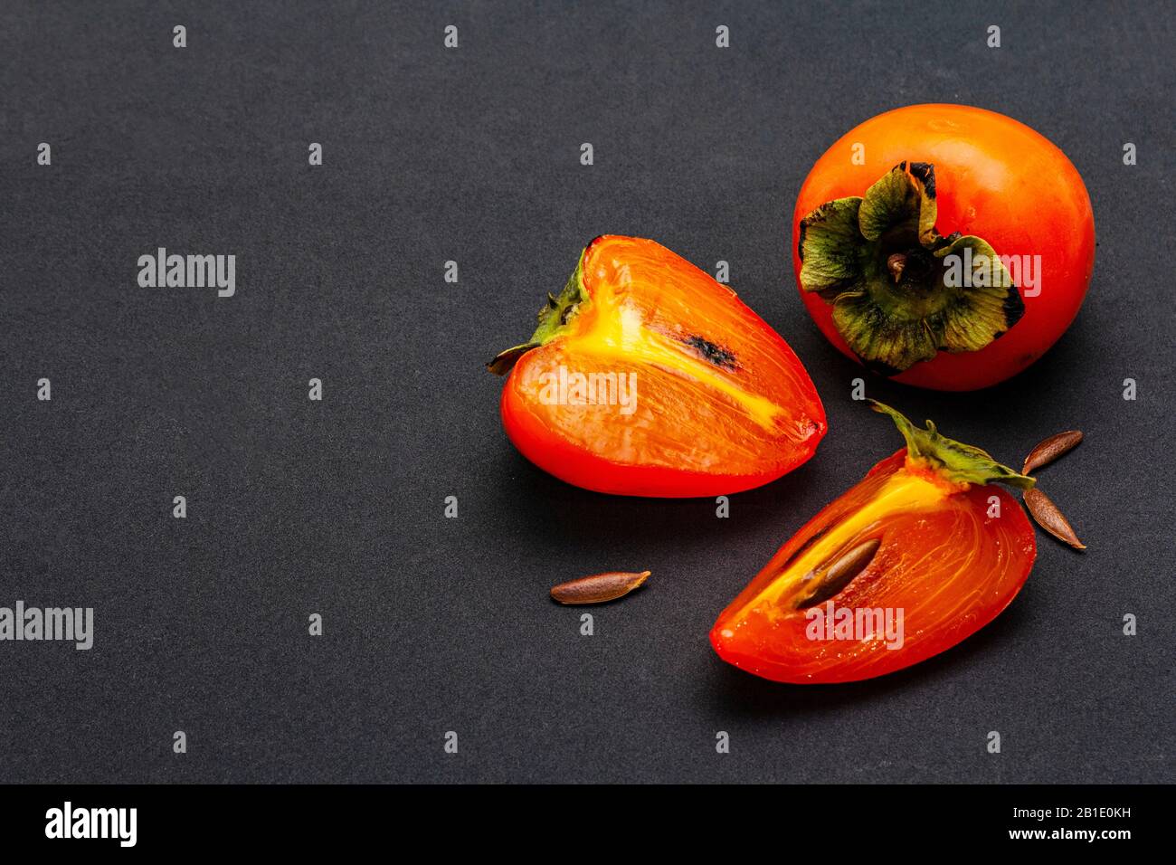 Ripe single persimmon. Fresh whole fruit, half sliced, seeds. Isolated ...