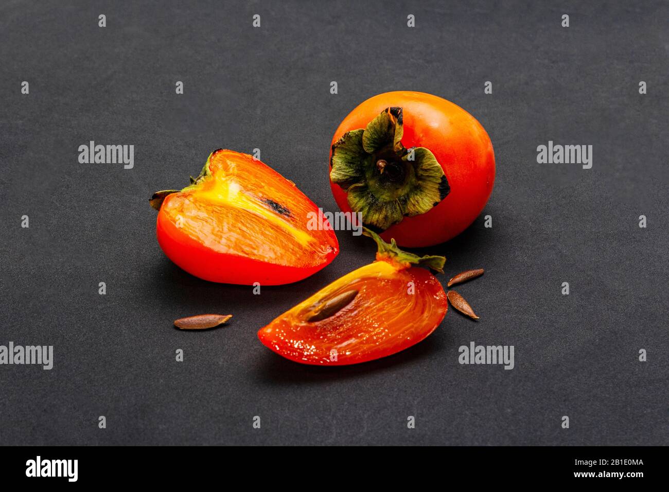 Ripe single persimmon. Fresh whole fruit, half sliced, seeds. Isolated ...