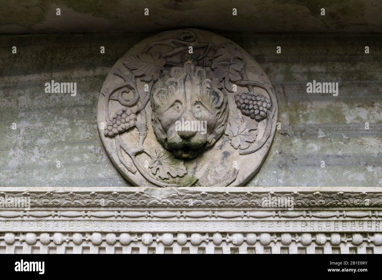Carved stone lion's head plaque, part of an ornate fountain, Castle Ashby Gardens, Northamptonshire, UK Stock Photo