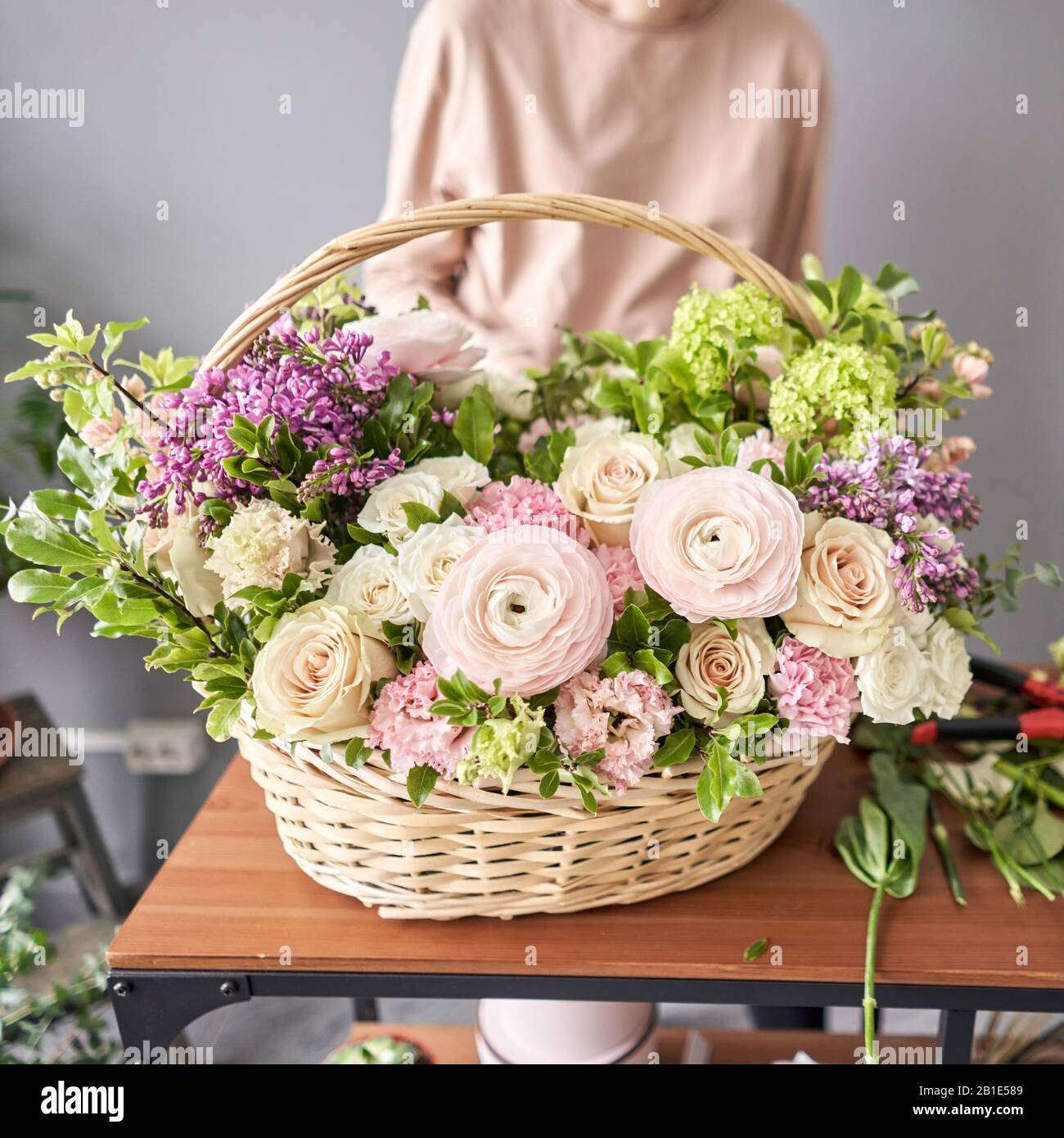Woman florist creating beautiful bouquet in flower shop. Work in flower