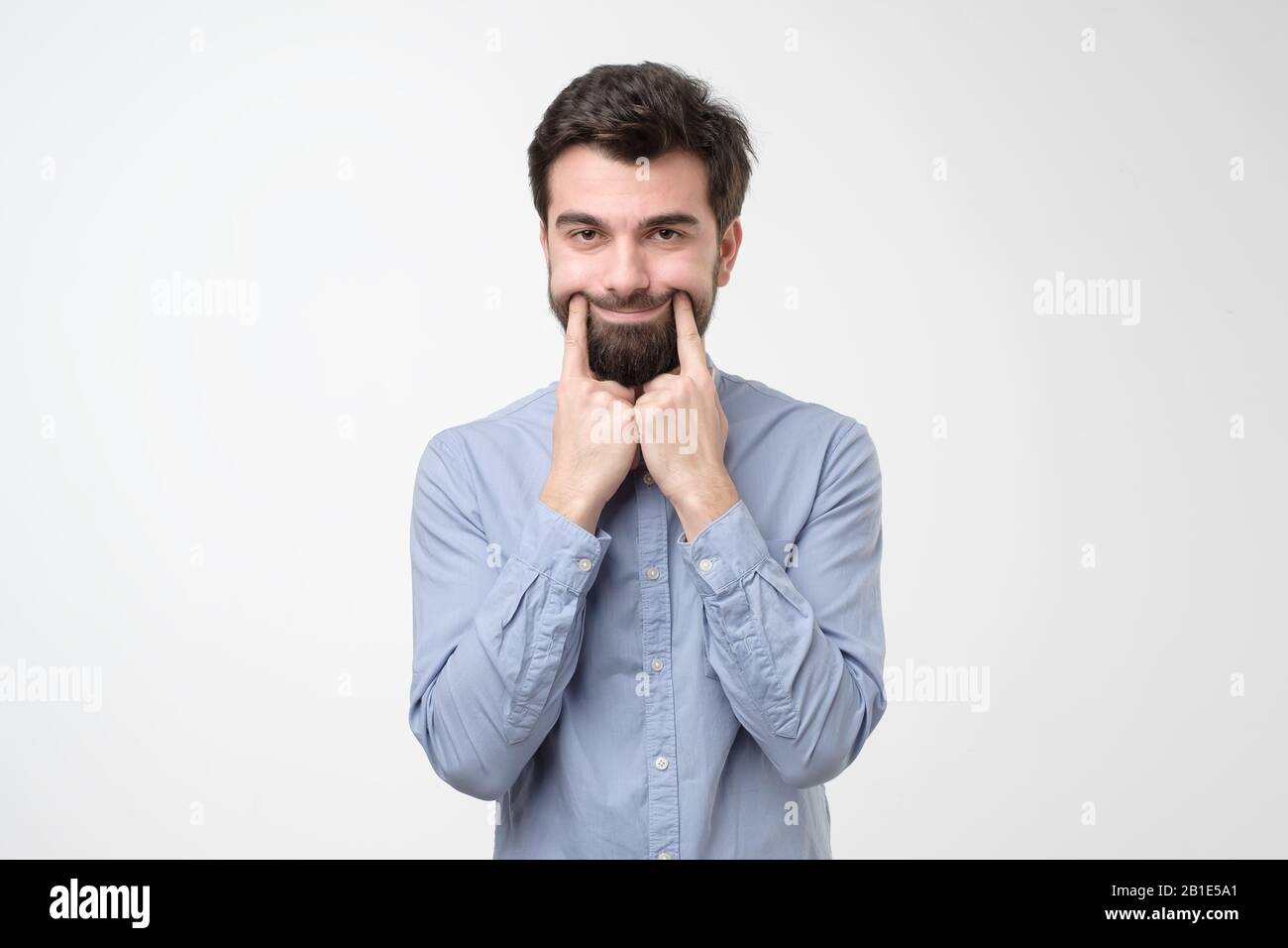 Nothing cheers him up. Sad young man trying to smile by lifting his ...