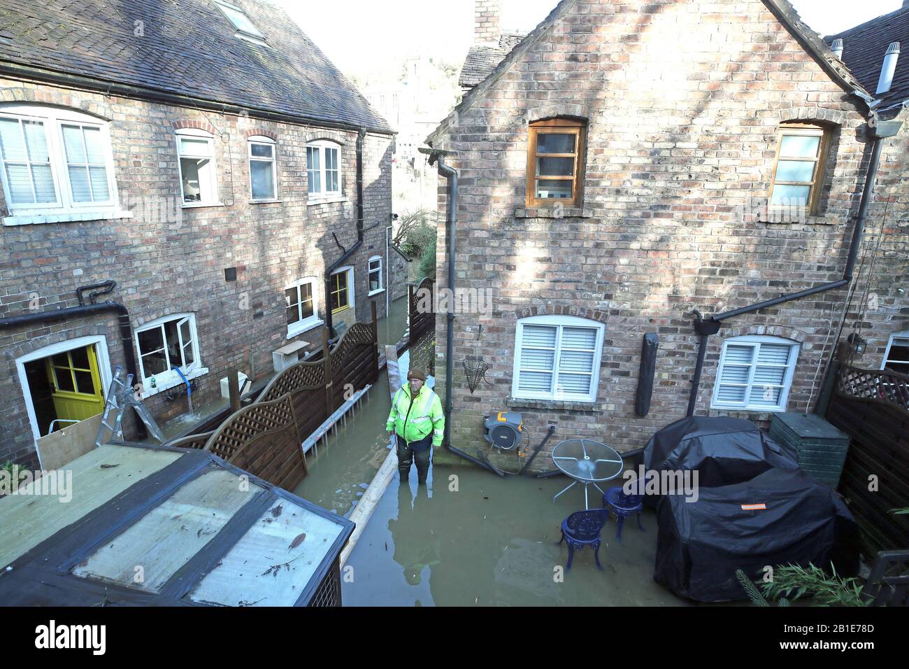 Vic Haddock surveys flooding behind houses in Ironbridge, Shropshire