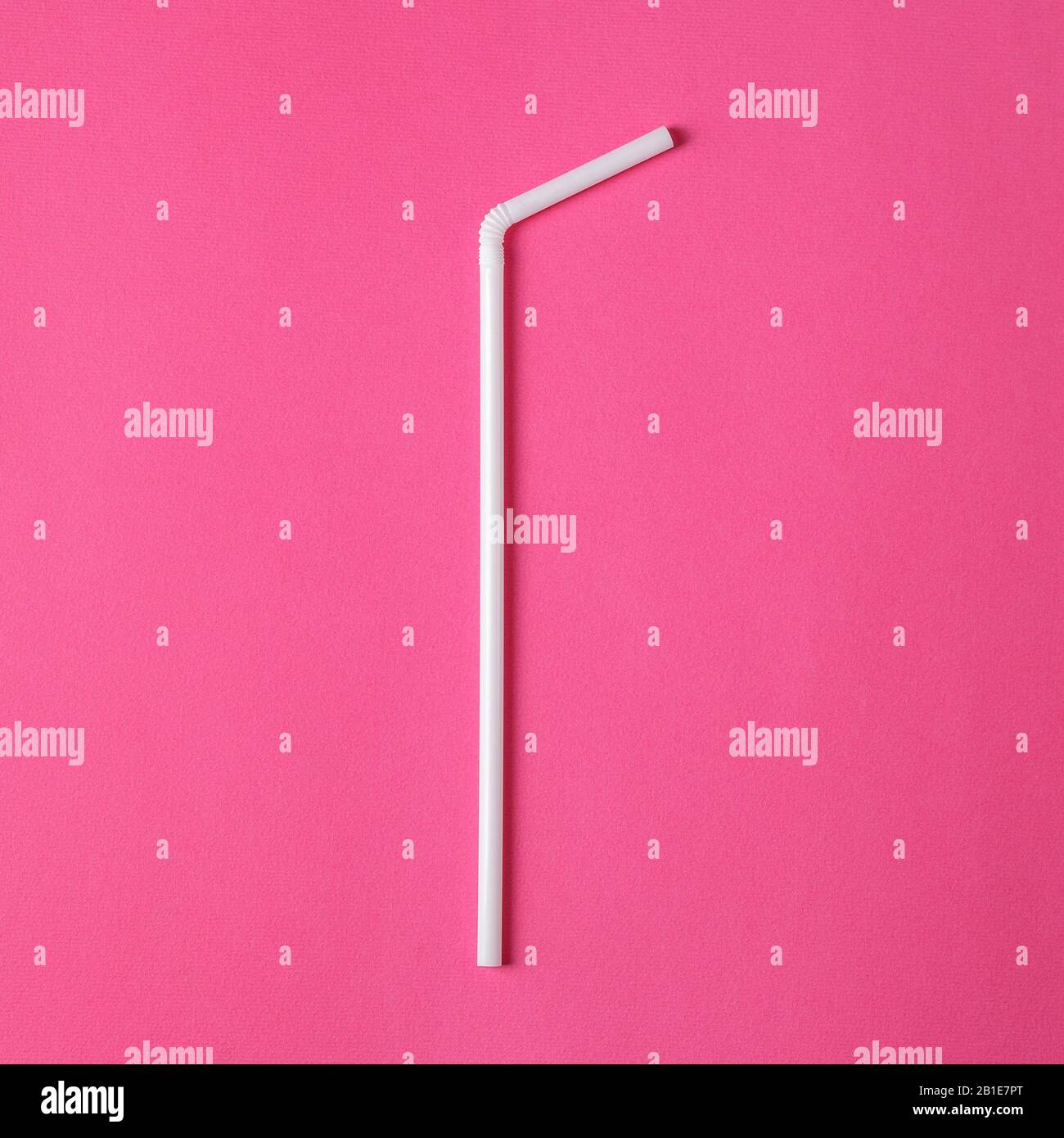 One white plastic straw on pink background. Plastic pollution. Environmental concept Stock Photo