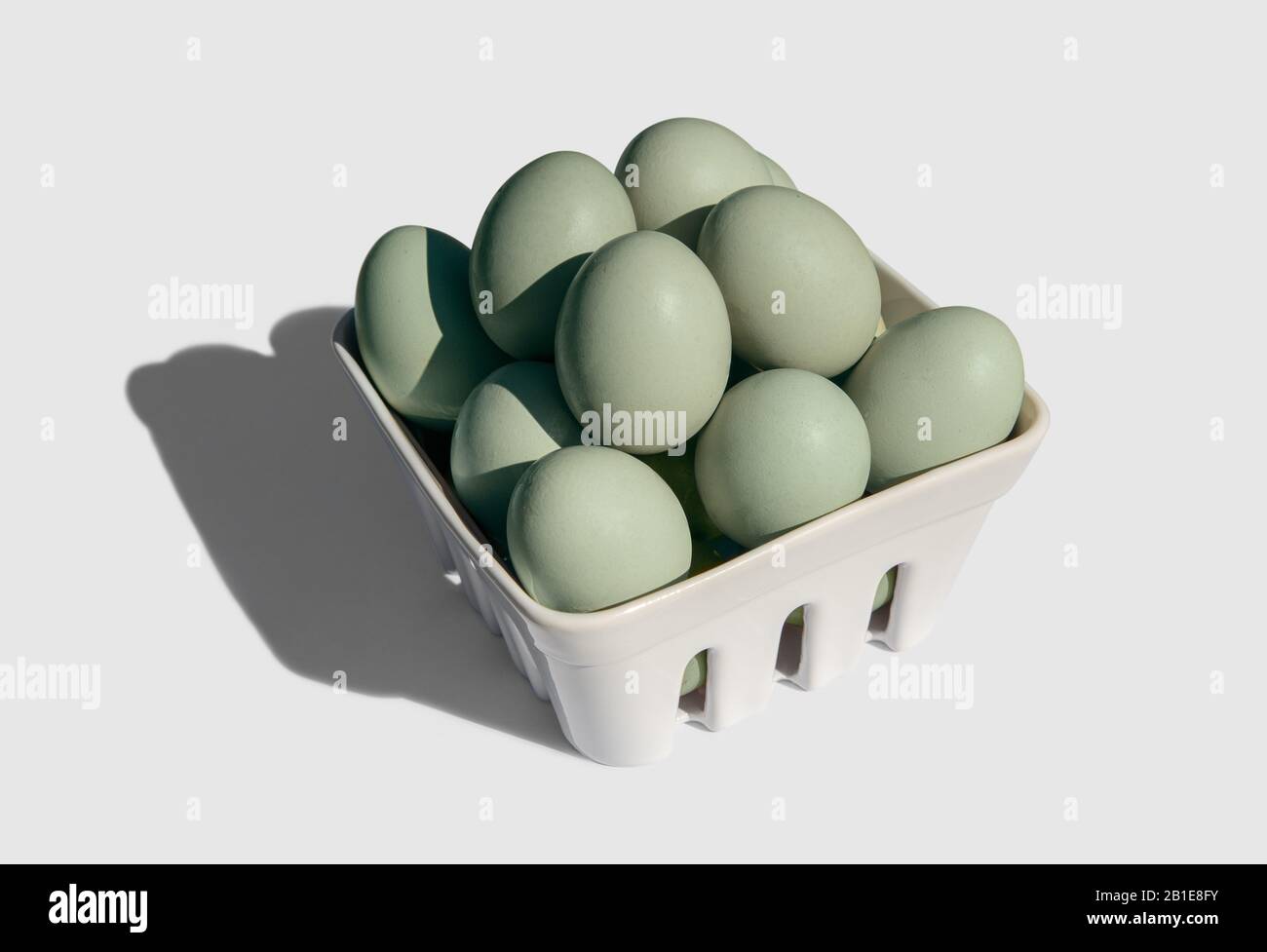 Araucana egg on basket isolated on white background. Blue or green eggs from Araucana chicken Stock Photo