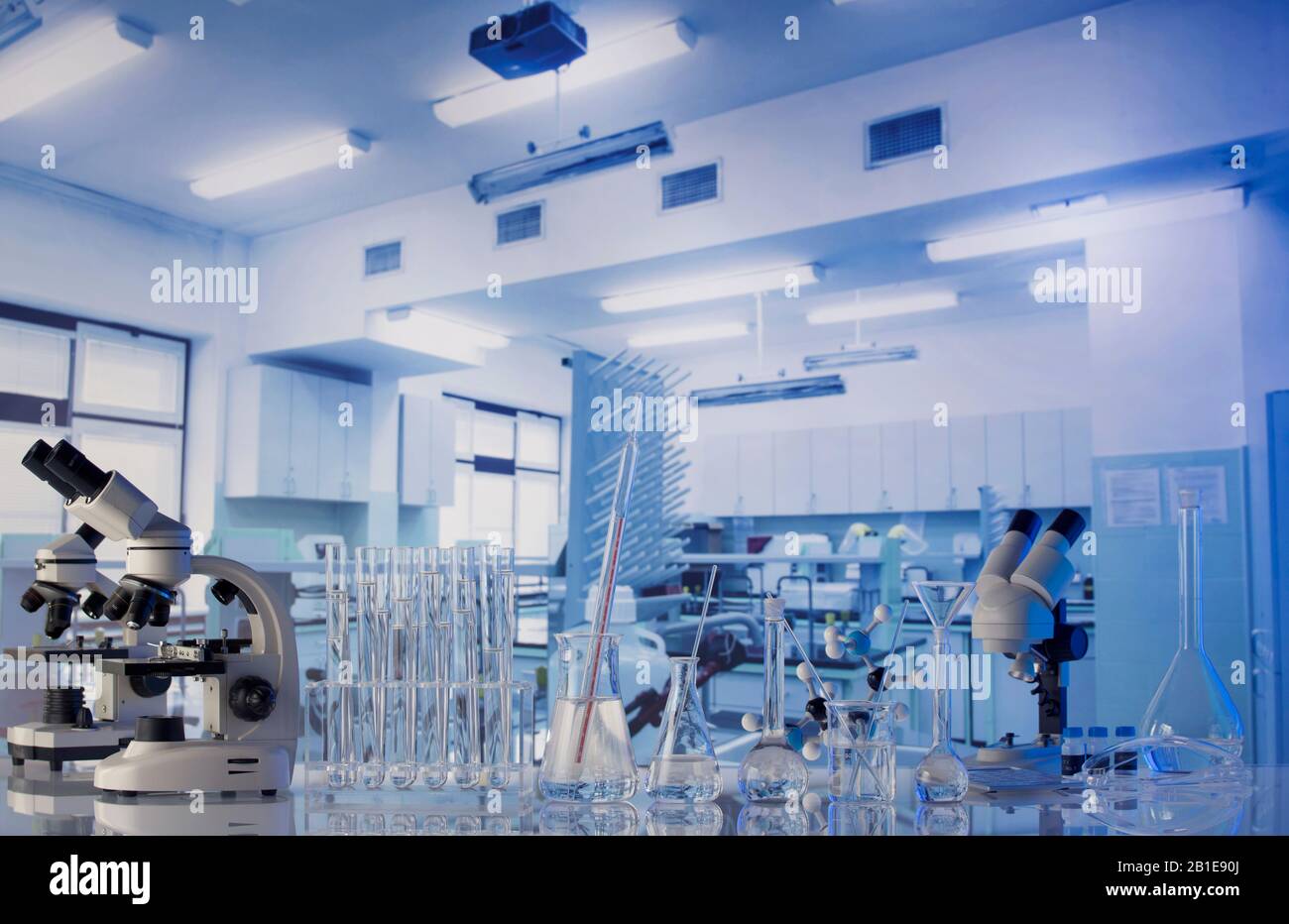 Science laboratory. Beakers, testtubes and microscope on glass table
