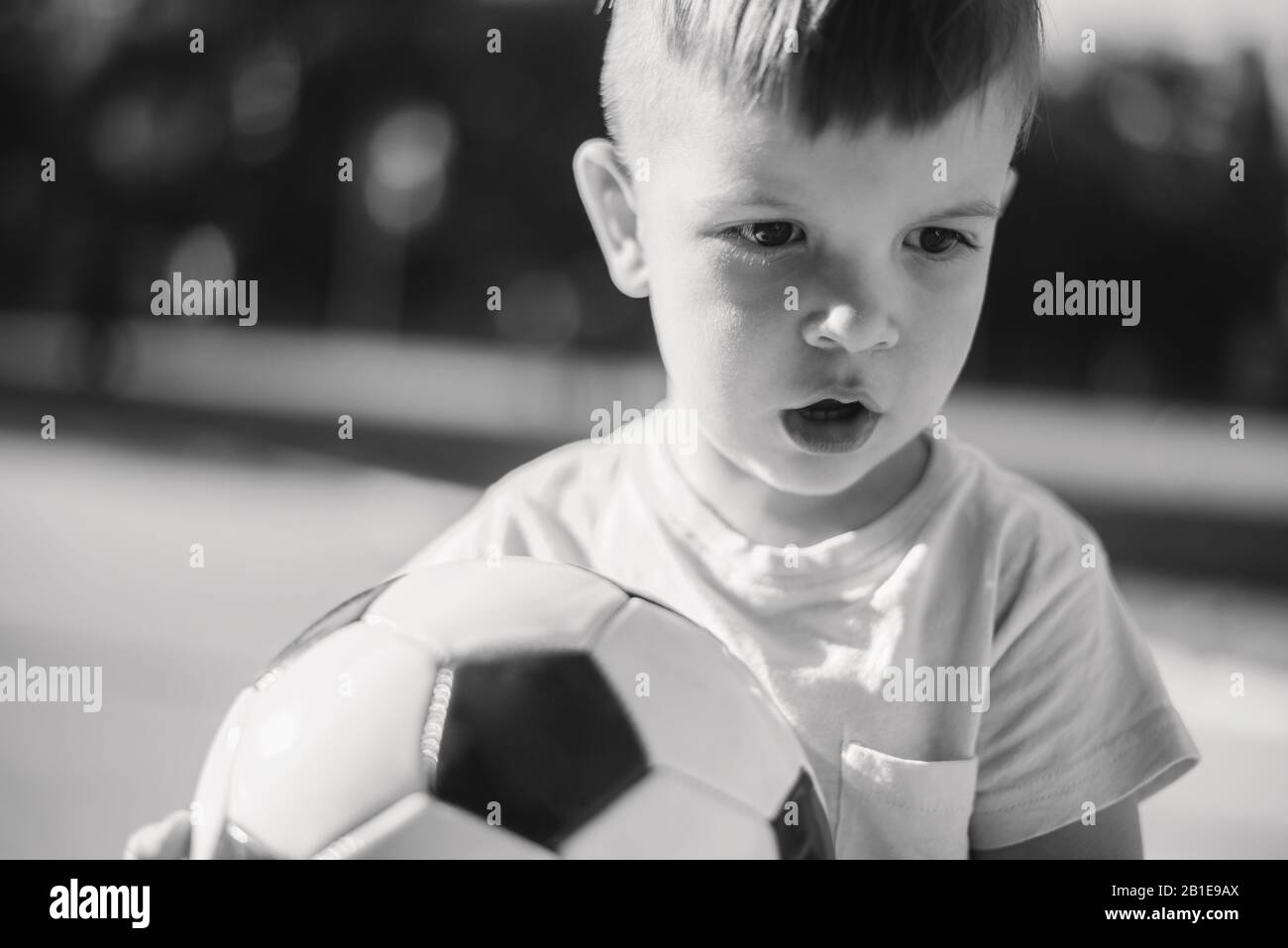 little kid playing football in a stadium on a sunny day Stock Photo - Alamy