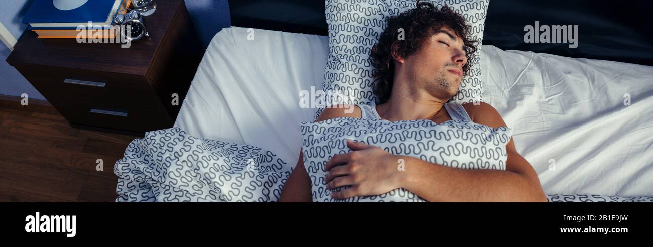 Man sleeping in bed at home Stock Photo