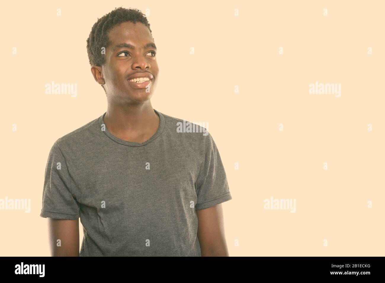 Studio shot of young happy black African teenage boy smiling and ...