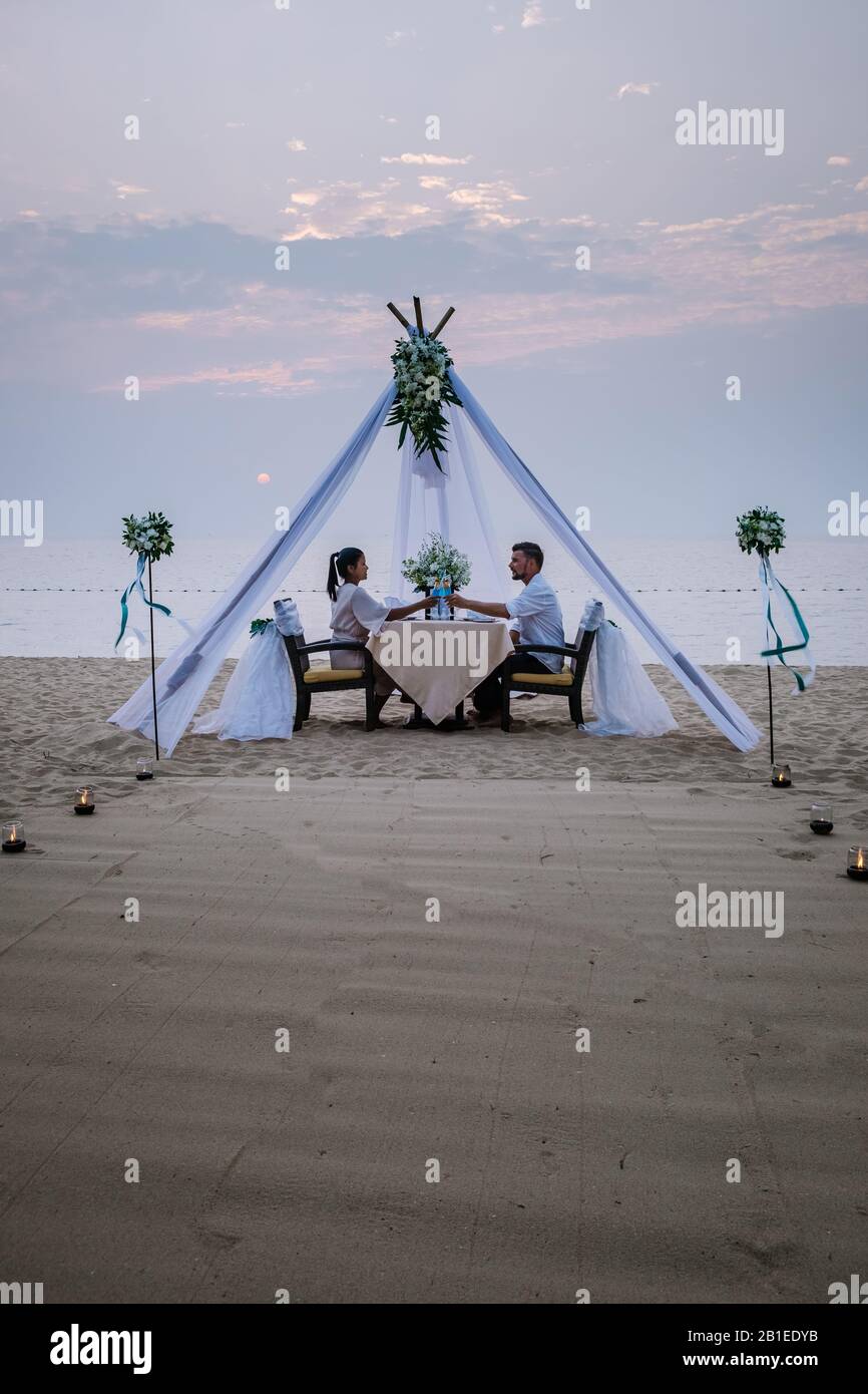 young couple Honeymoon dinner by candle light during sunset on the ...