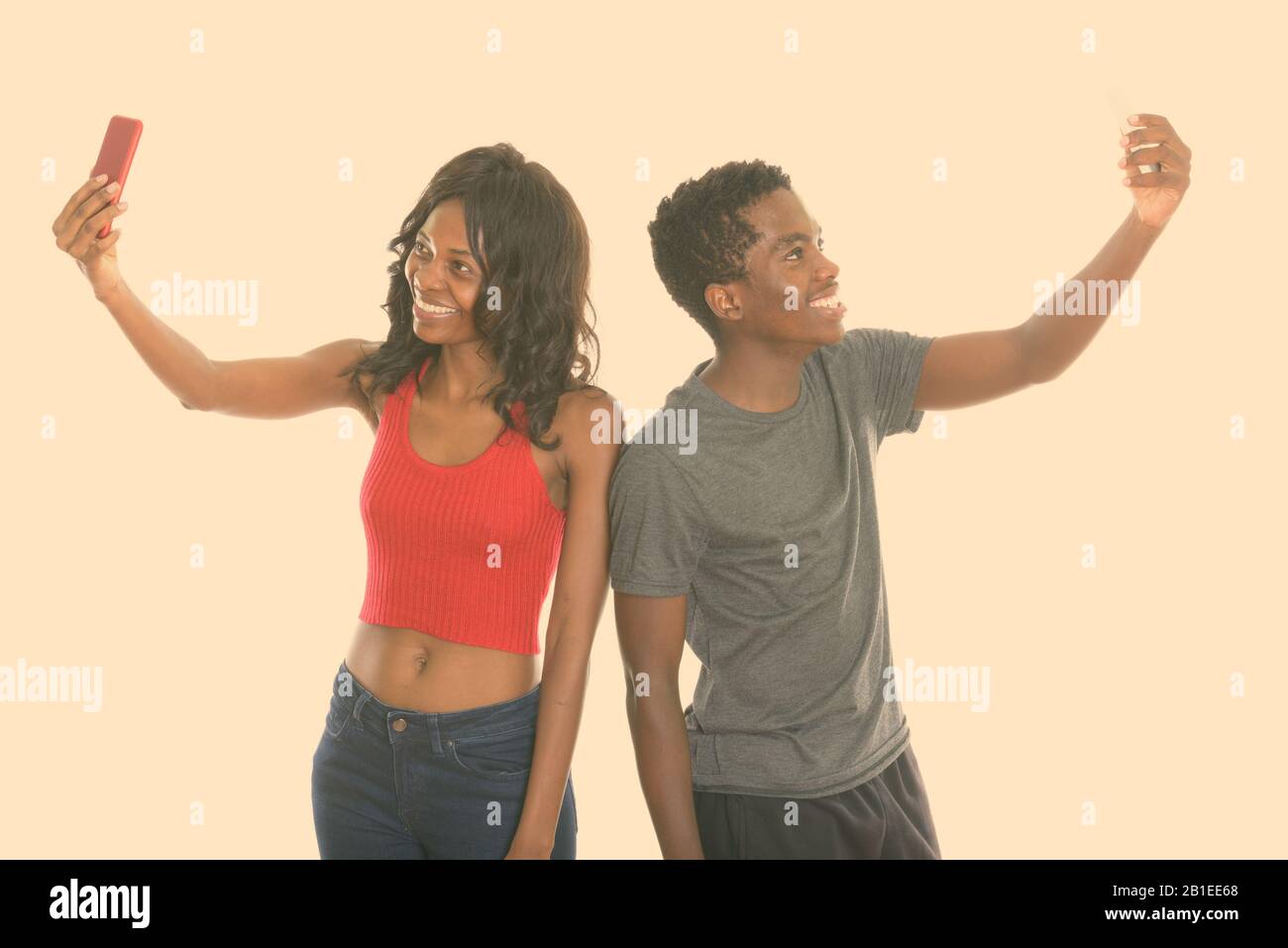 Happy young African sister and brother while taking selfie picture with mobile phone together Stock Photo