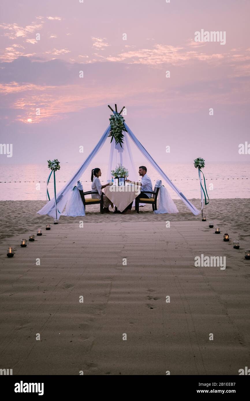 young couple Honeymoon dinner by candle light during sunset on the ...