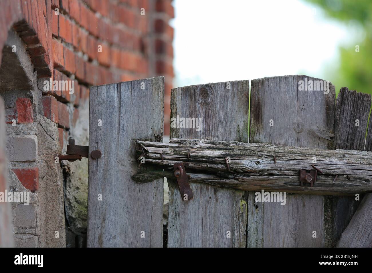 Detal of rustic old wooden gate in brick wall, countryside scene Stock Photo Alamy