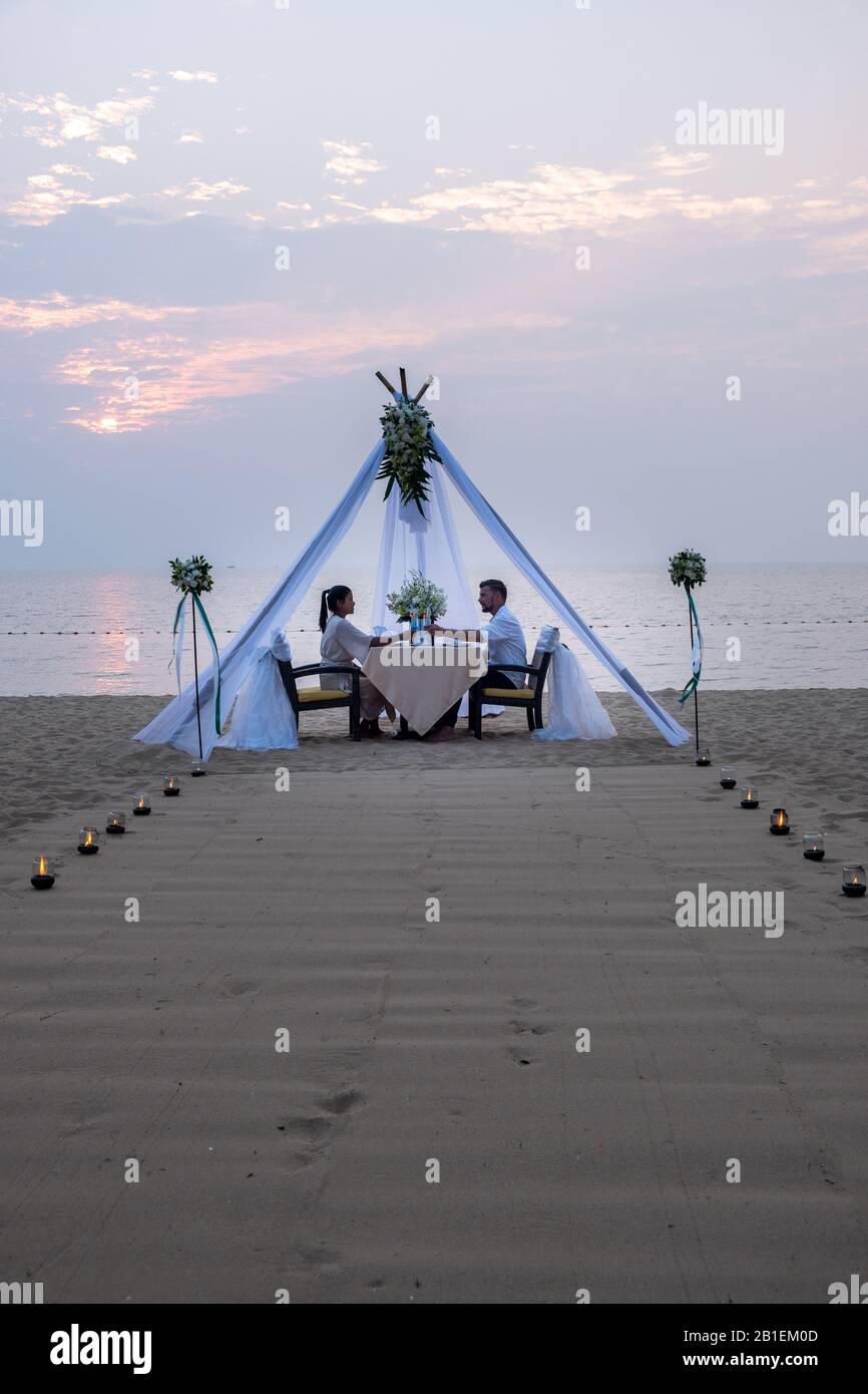 young couple Honeymoon dinner by candle light during sunset on the ...