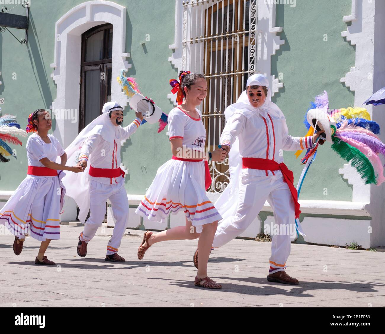 Litter of Huehues in traditional Mexican costumes at Tlaxcala Carnival, White dressed with feather hat in couples dancing  Tlaxcala, Mexico, Stock Photo