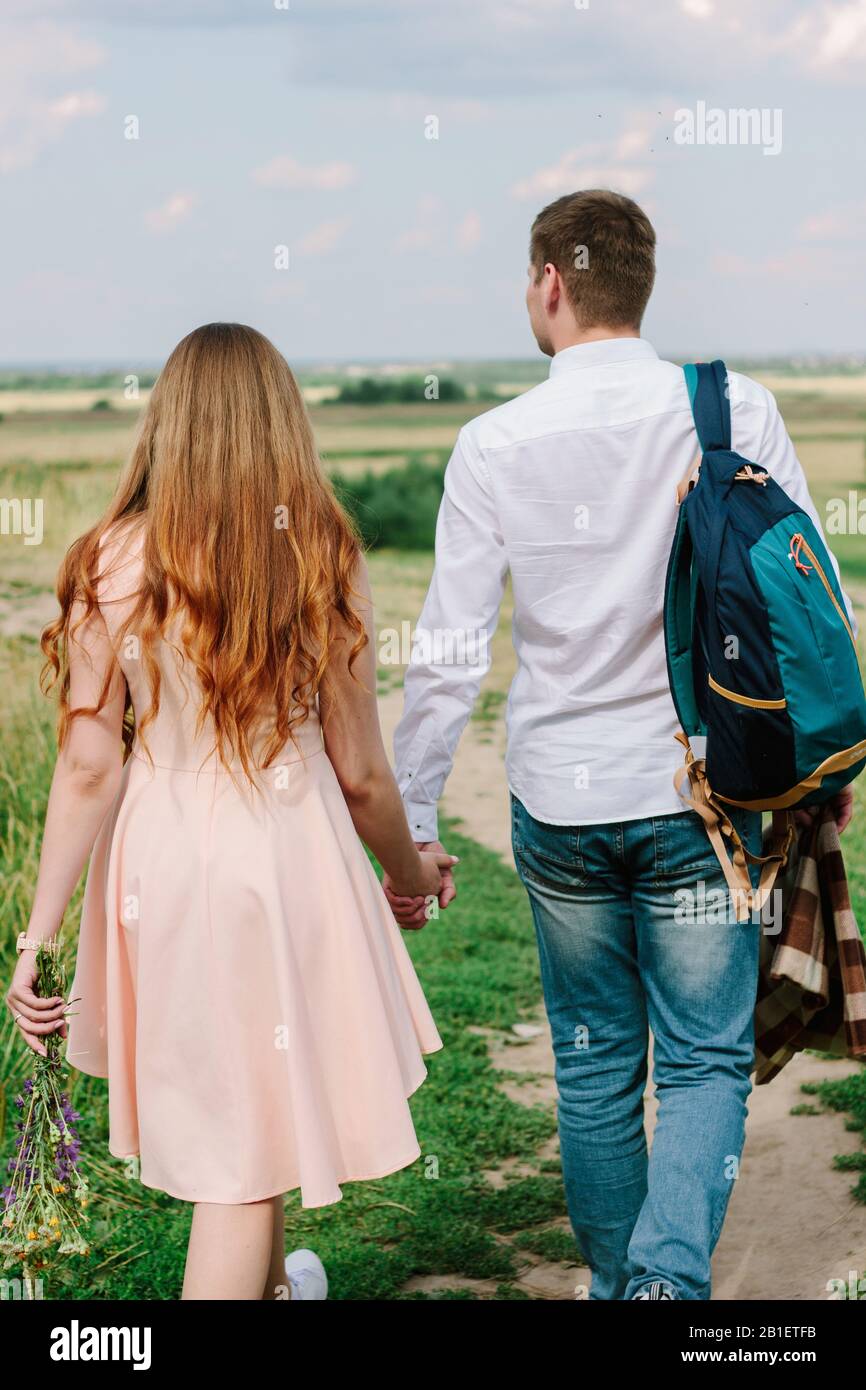 Back view of young couple walking on the nature Stock Photo - Alamy