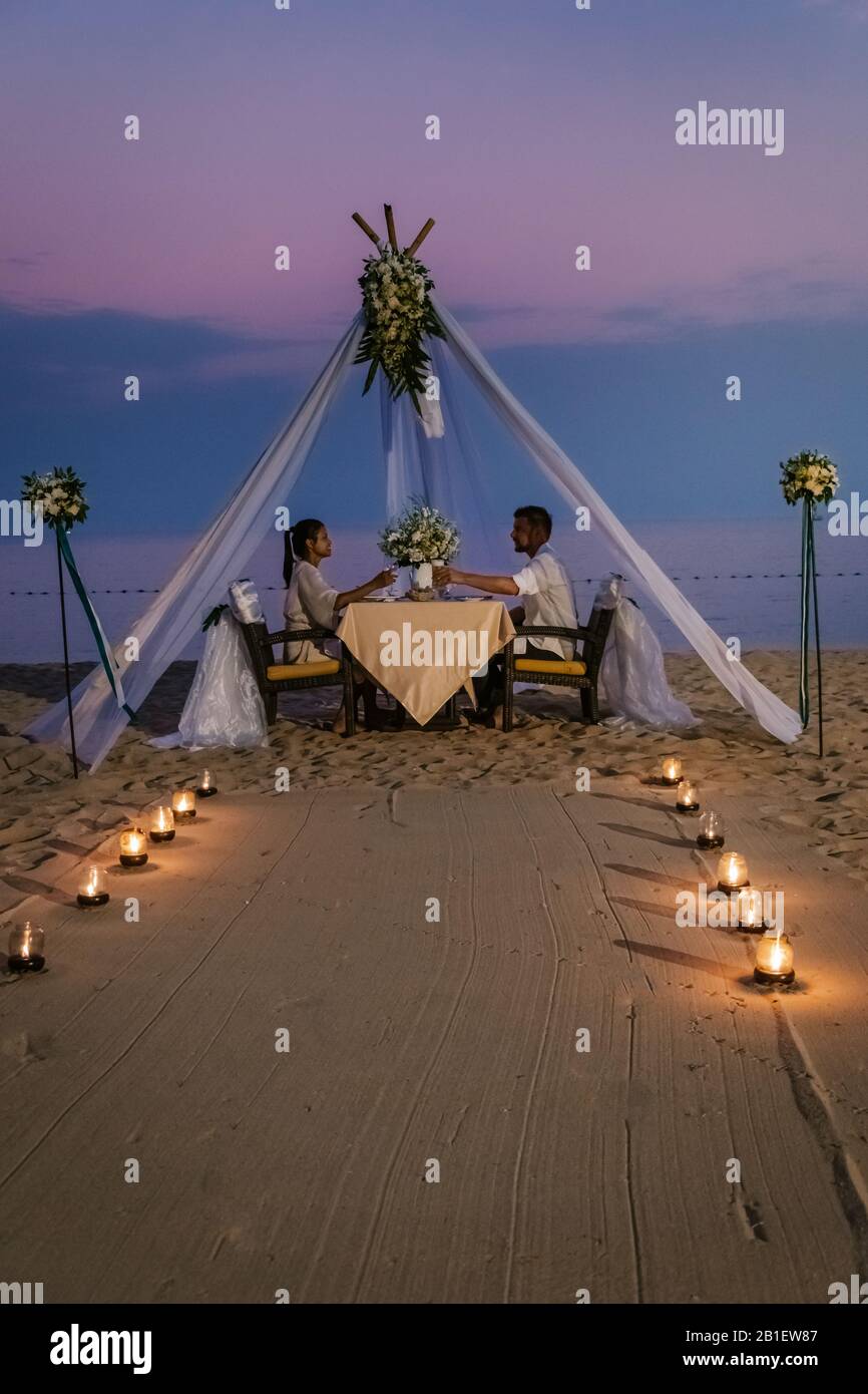young couple Honeymoon dinner by candle light during sunset on the
