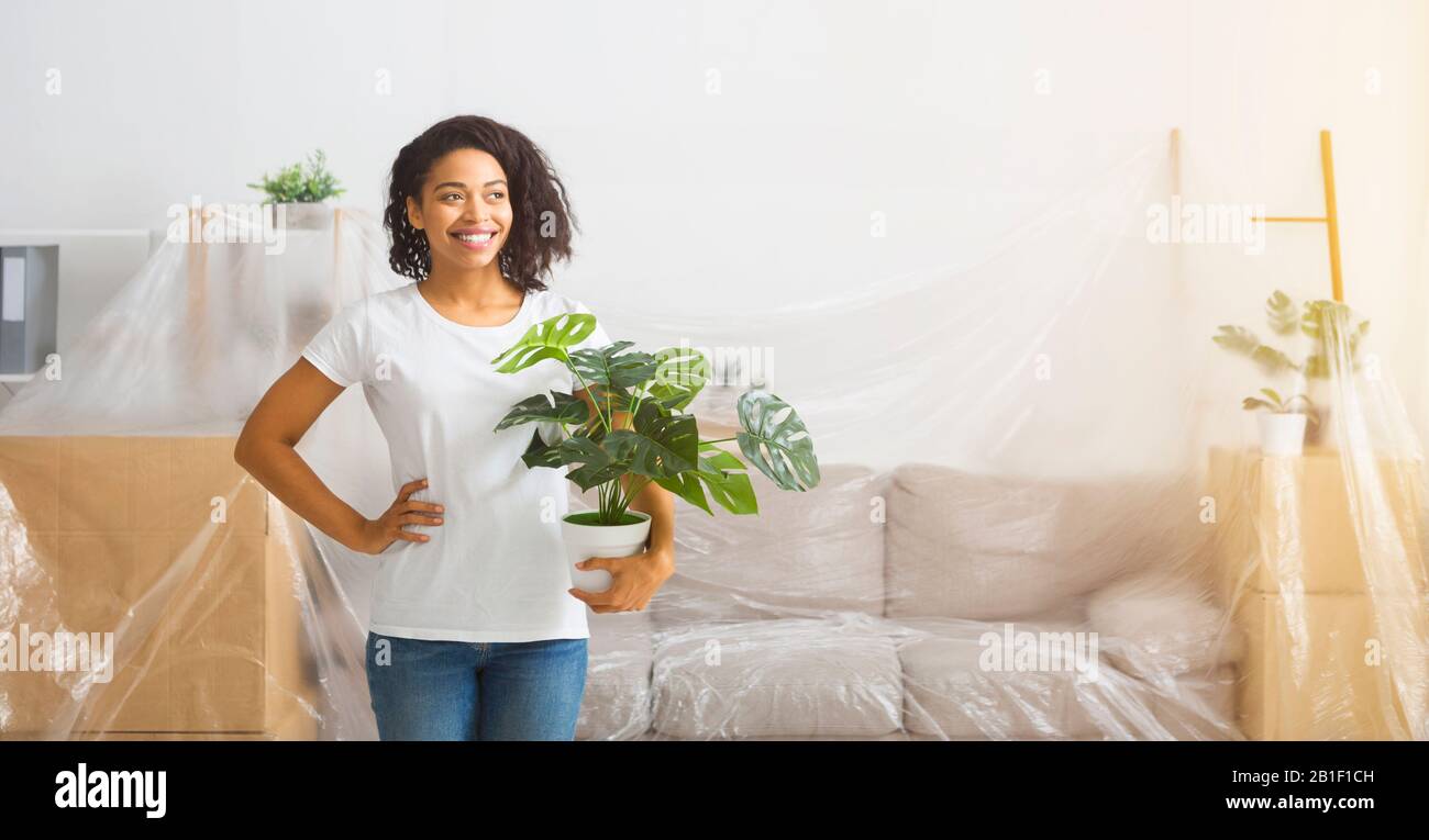 Repair Preparation. furniture covered happy girl with a plant Stock Photo