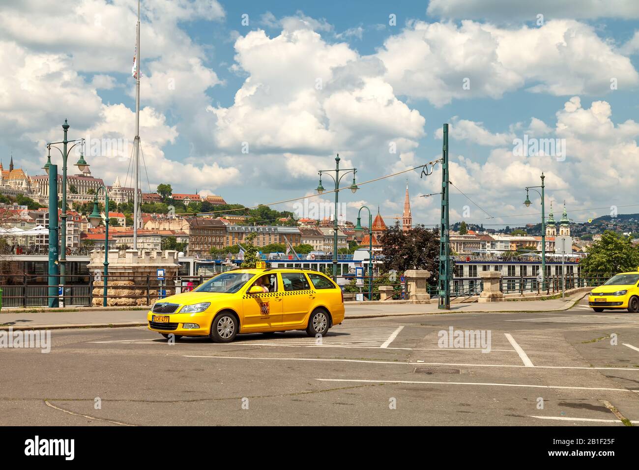 A yellow taxi car stands on the square near the Danube embankment in the center of Budapest and is waiting for its passengers. Bright, warm sunny day Stock Photo