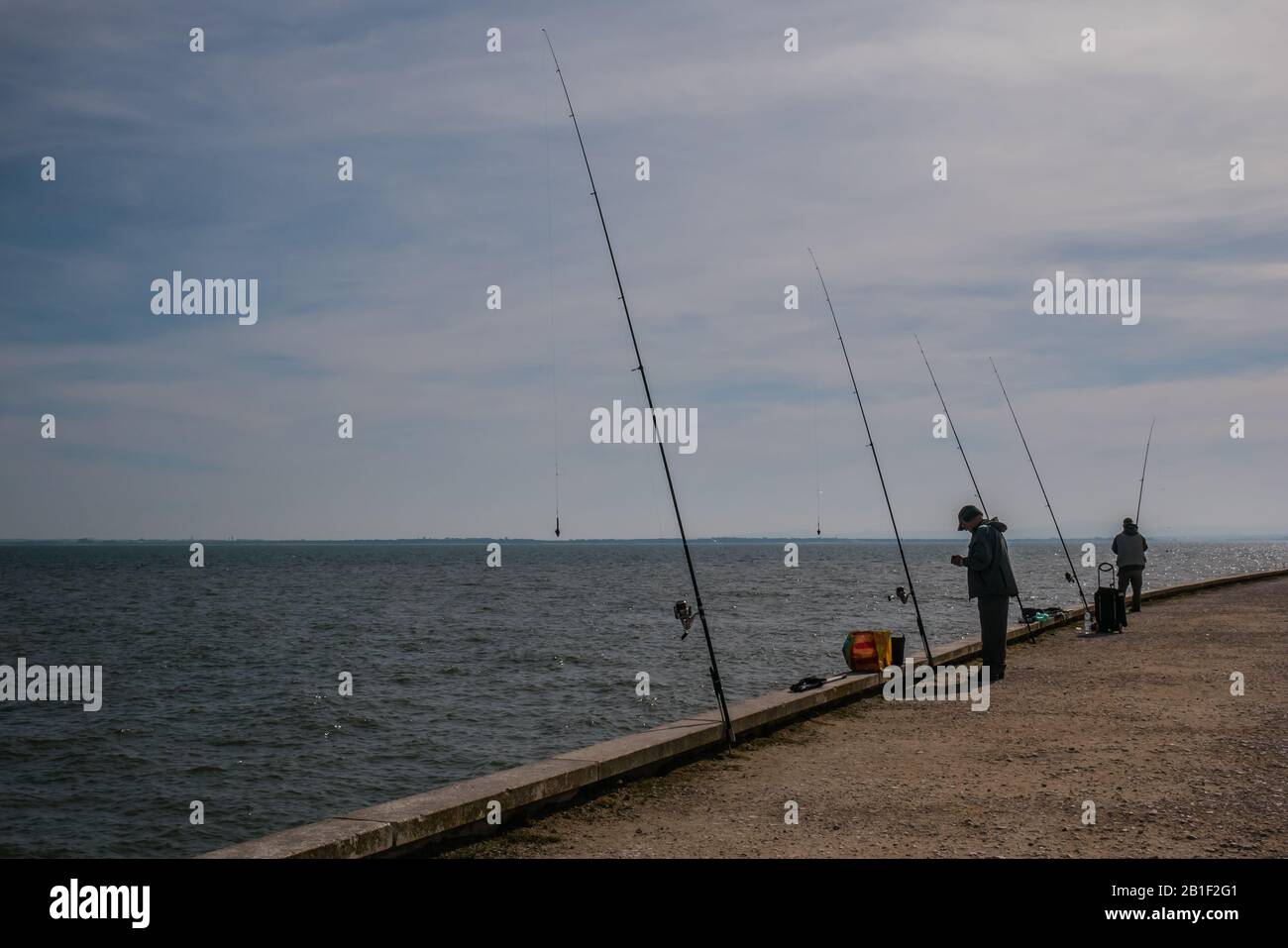 people fishing along the coast ot tagus river lisbon portugal Stock Photo
